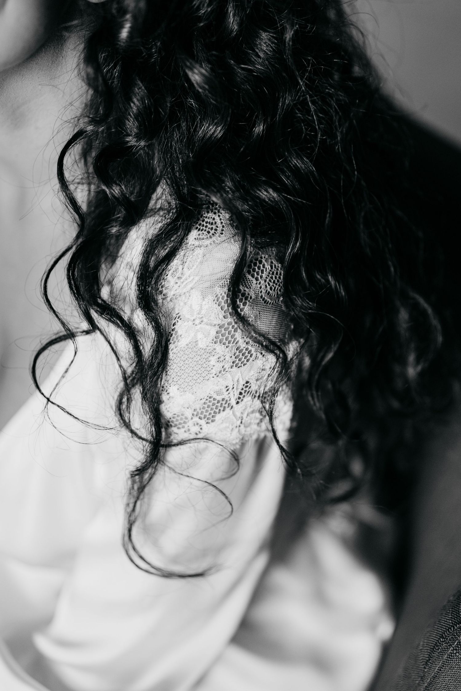 Artistic black and white close-up of curly hair against light background.
