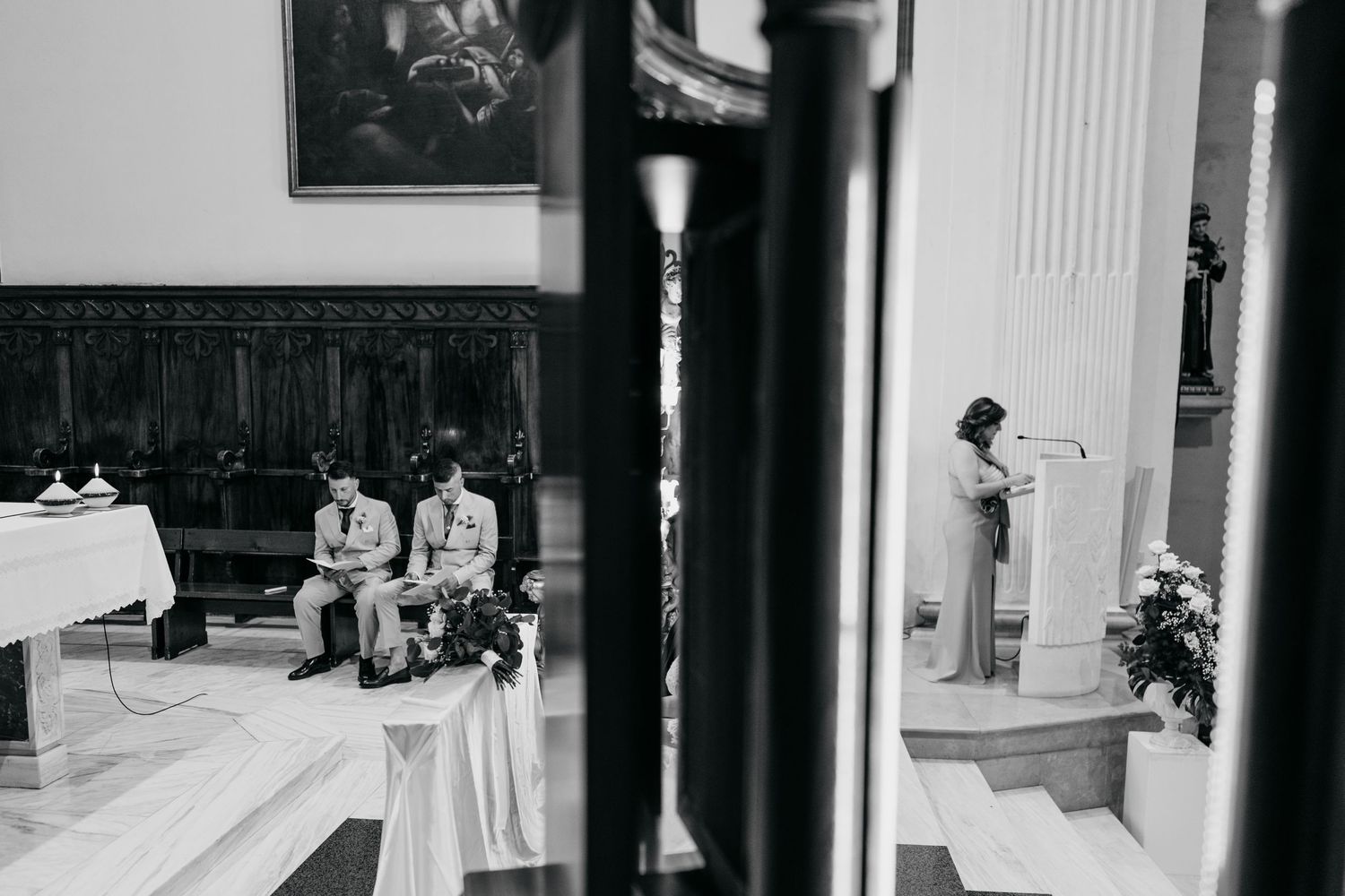 Black and white architectural photo of classical columns in a formal building interior.
