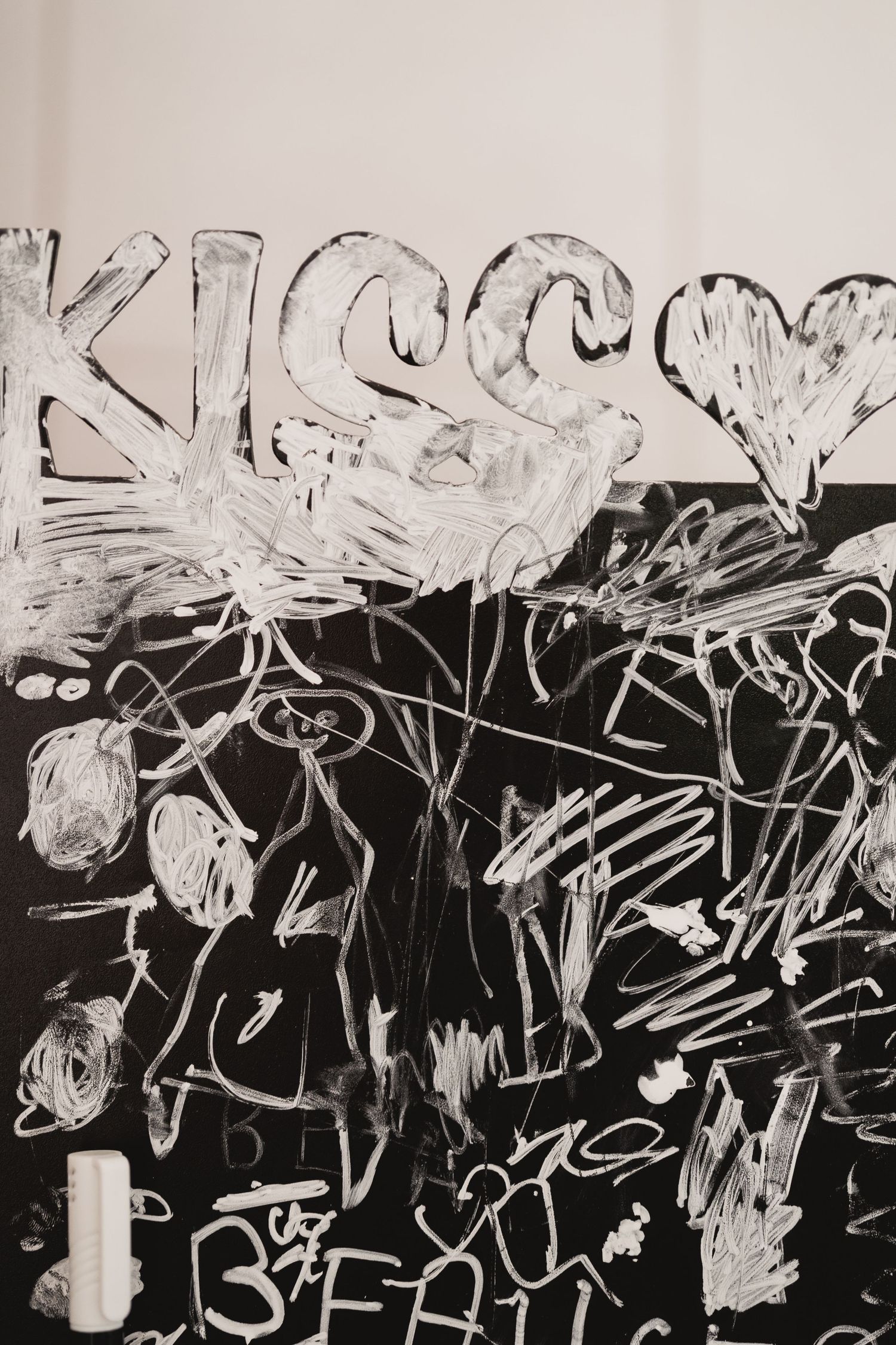 Black and white chalkboard drawing with scribbles and abstract heart shapes.