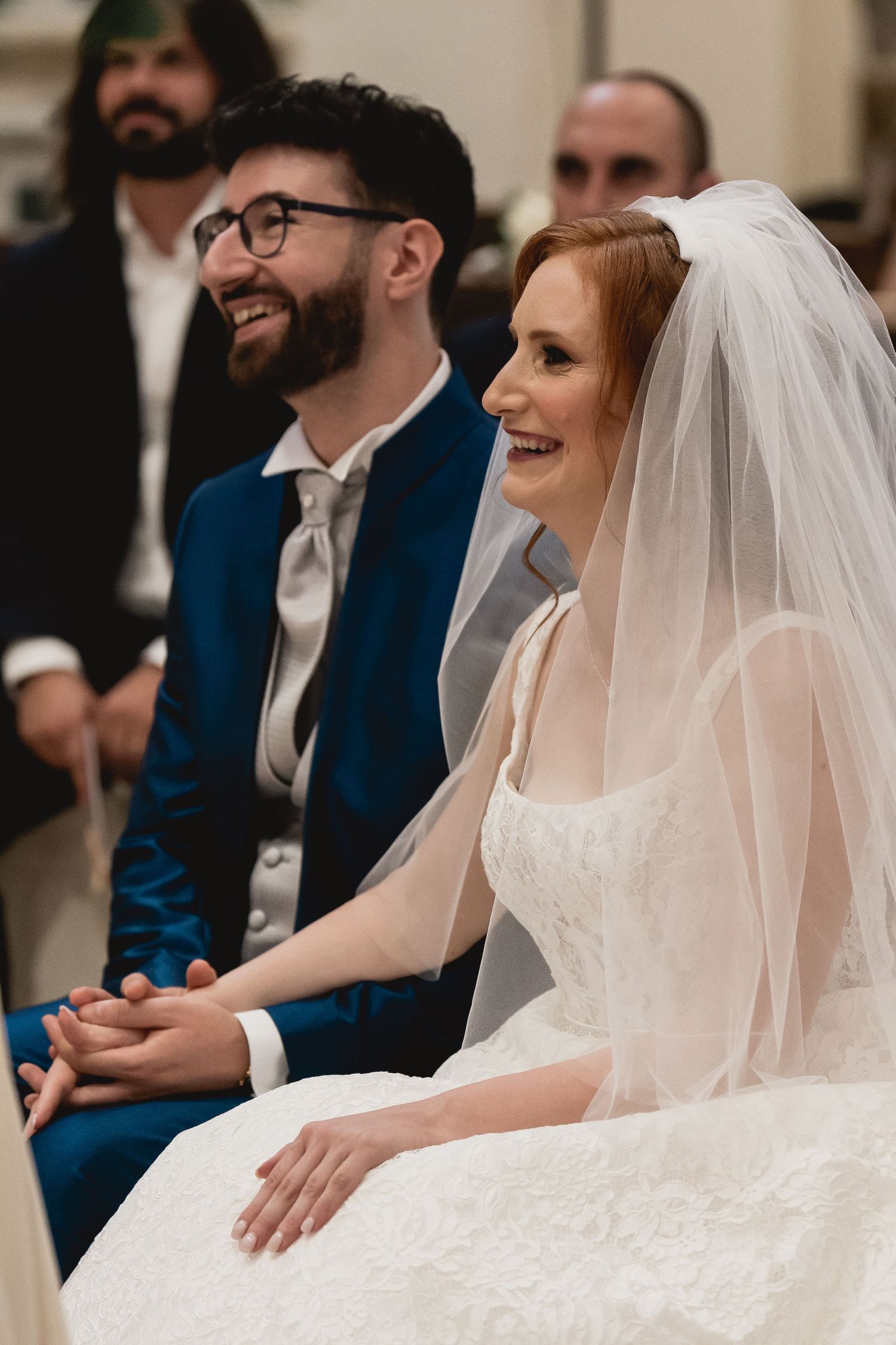 Wedding couple shares joyful moment during ceremony in church setting.