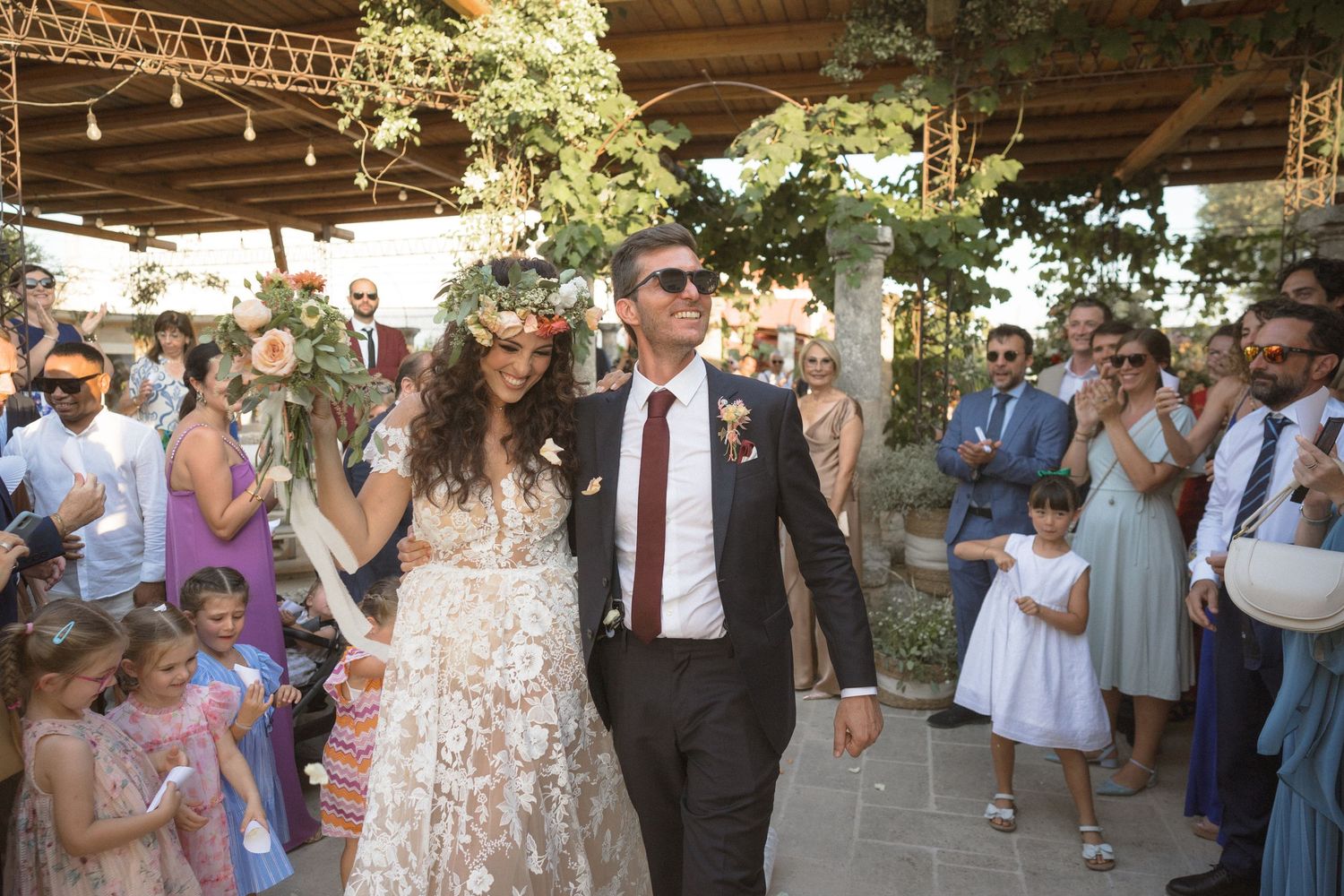 Wedding celebration with guests gathered under a covered outdoor venue.