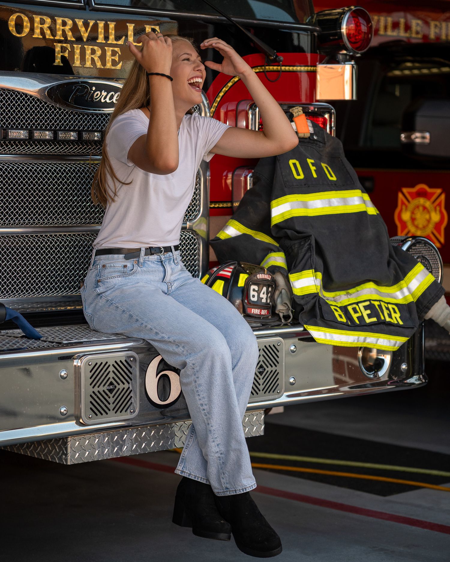 Sitting on edge of fire truck with Orrville Fire Department lettering in background.