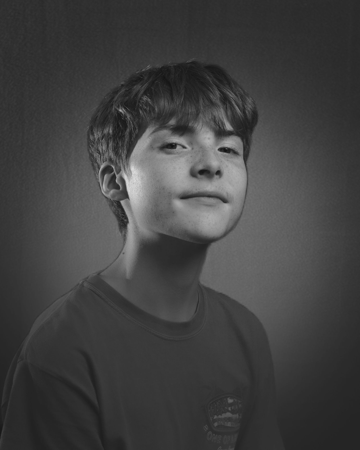 Dramatic black and white portrait with moody lighting and dark background.