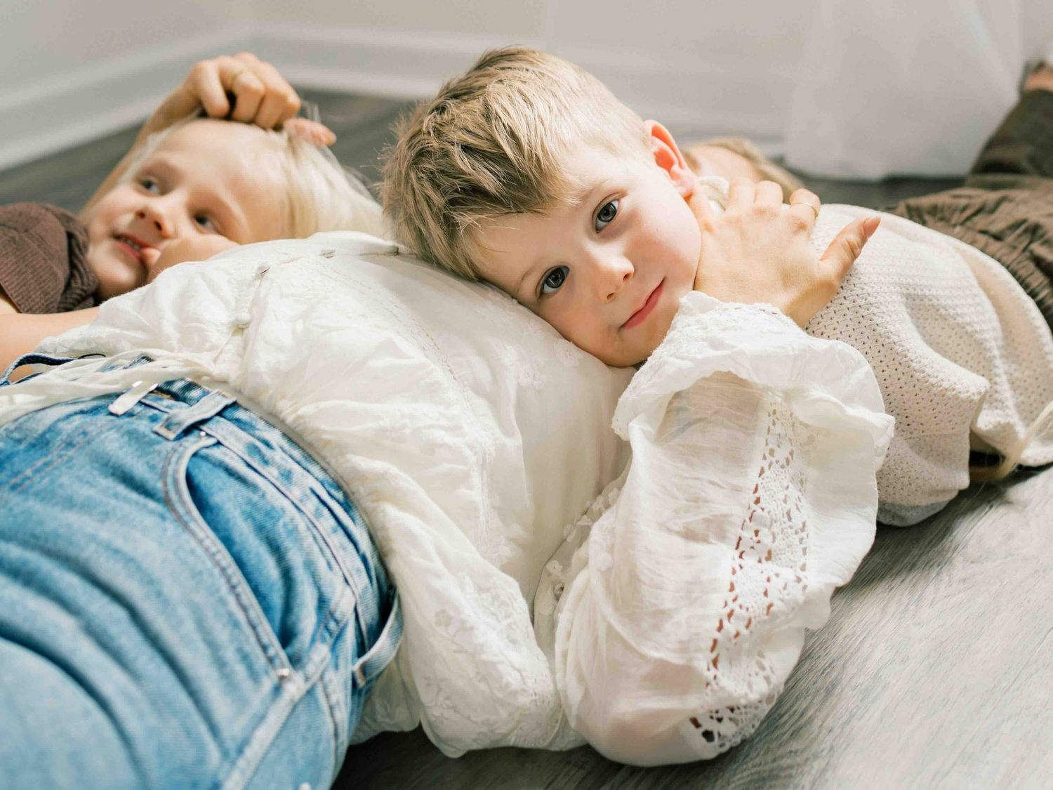 Mom cuddling sons during relaxed outdoor family session in Fairhope Alabama