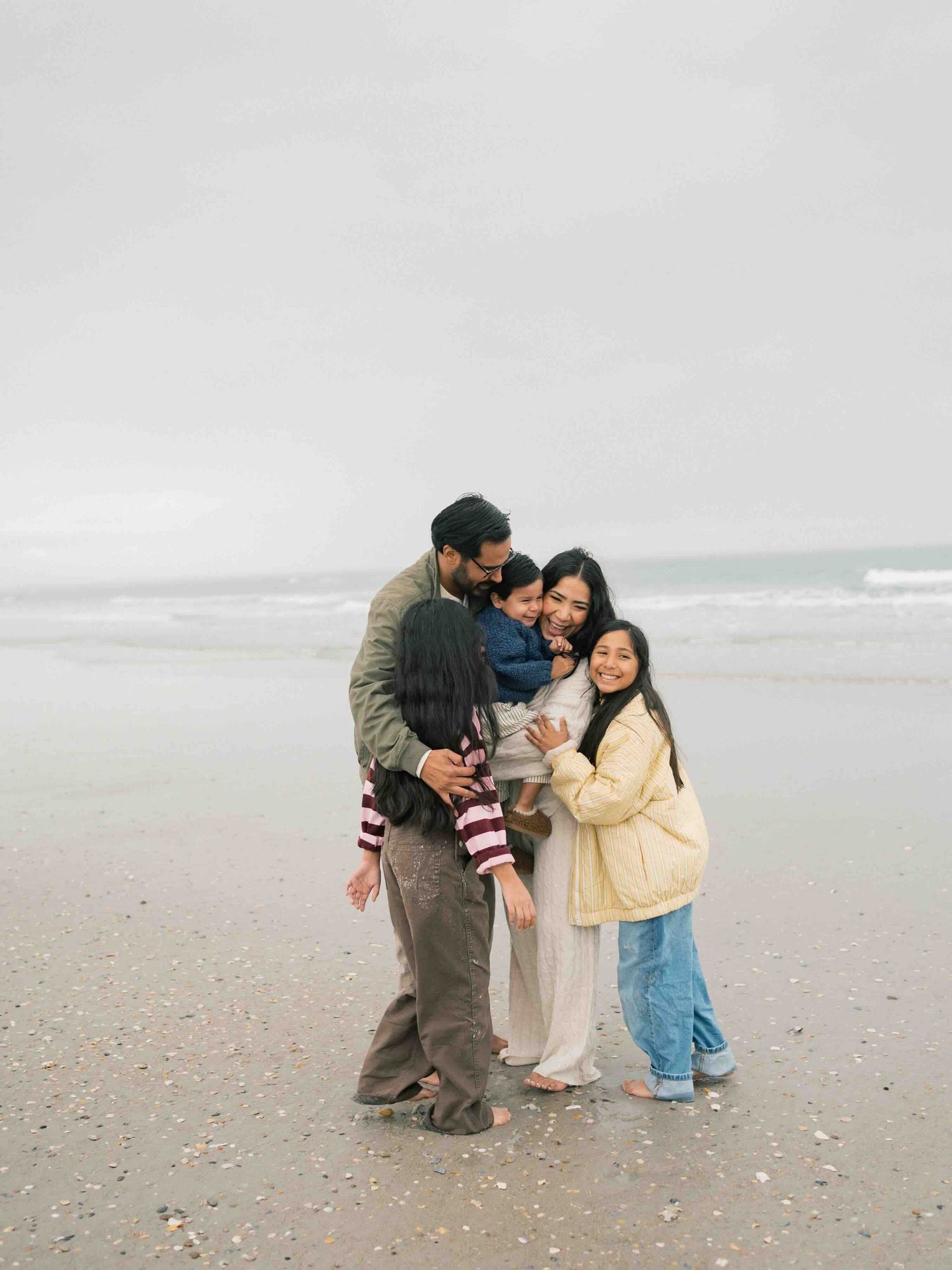 Family group hug during sunset family photography session in Dauphin Island Alabama