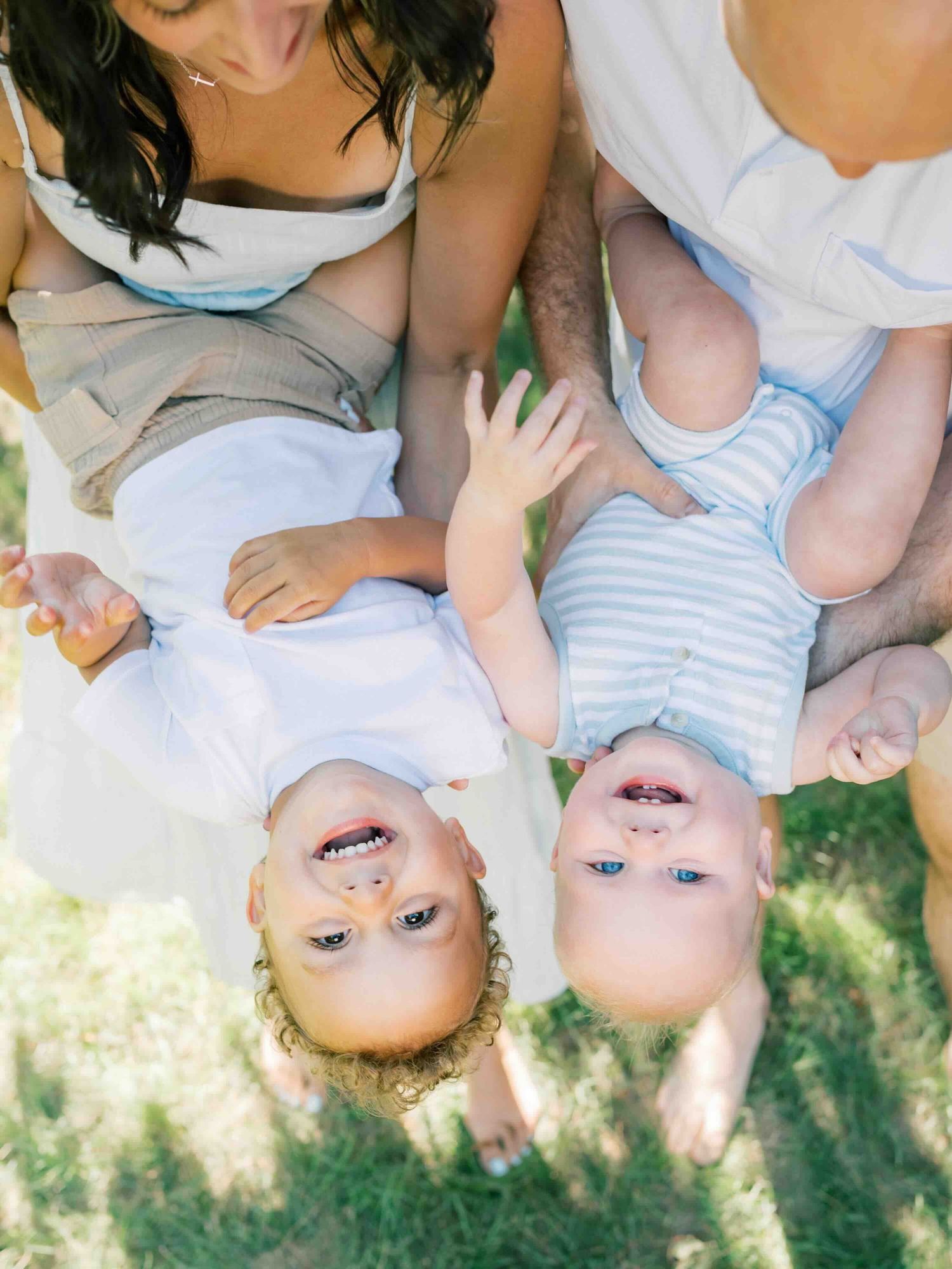 Parents holding their two young boys during a relaxed family photography session in Mobile, Alabama.
