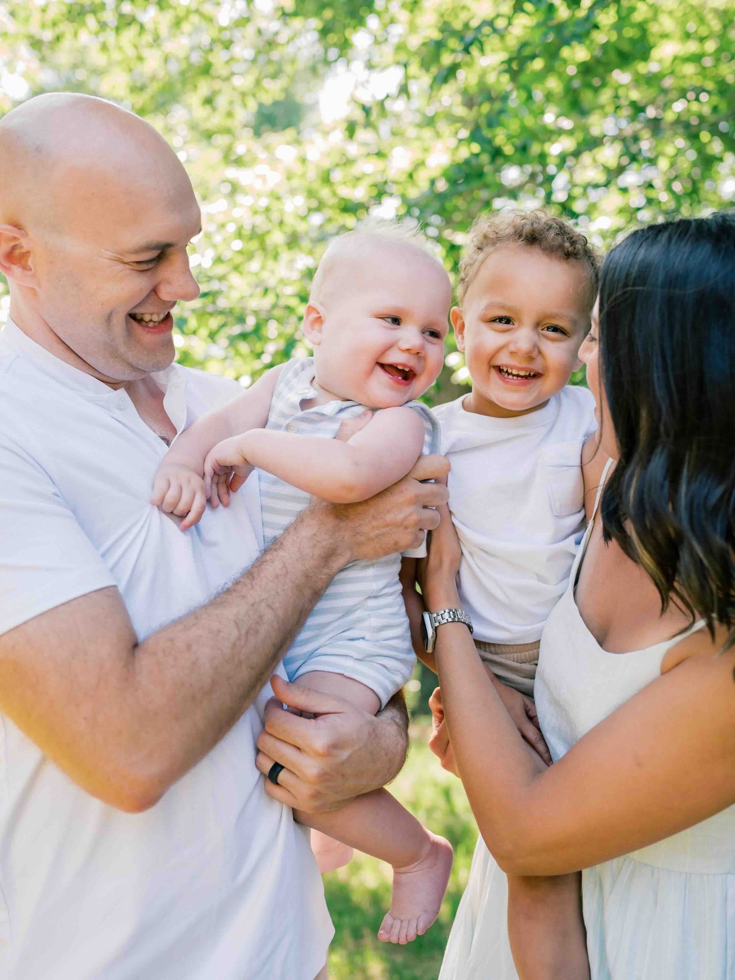 Young family embracing the chaos during their outdoor family photos in Mobile, Alabama.