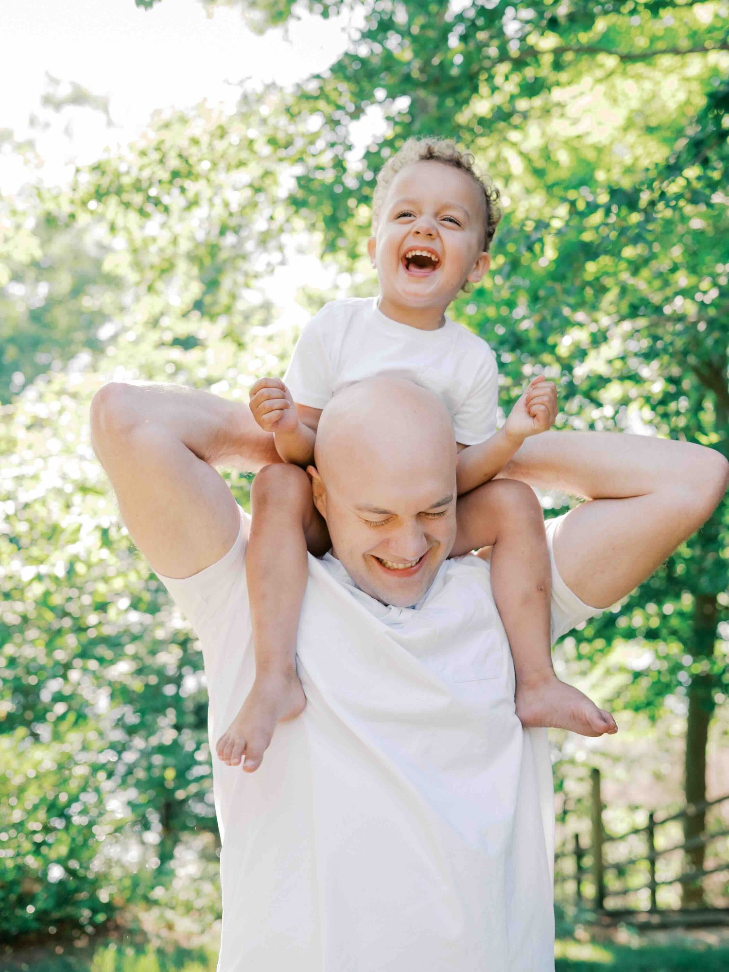 Dad carrying son on shoulders during a golden hour photo shoot in Mobile, Alabama