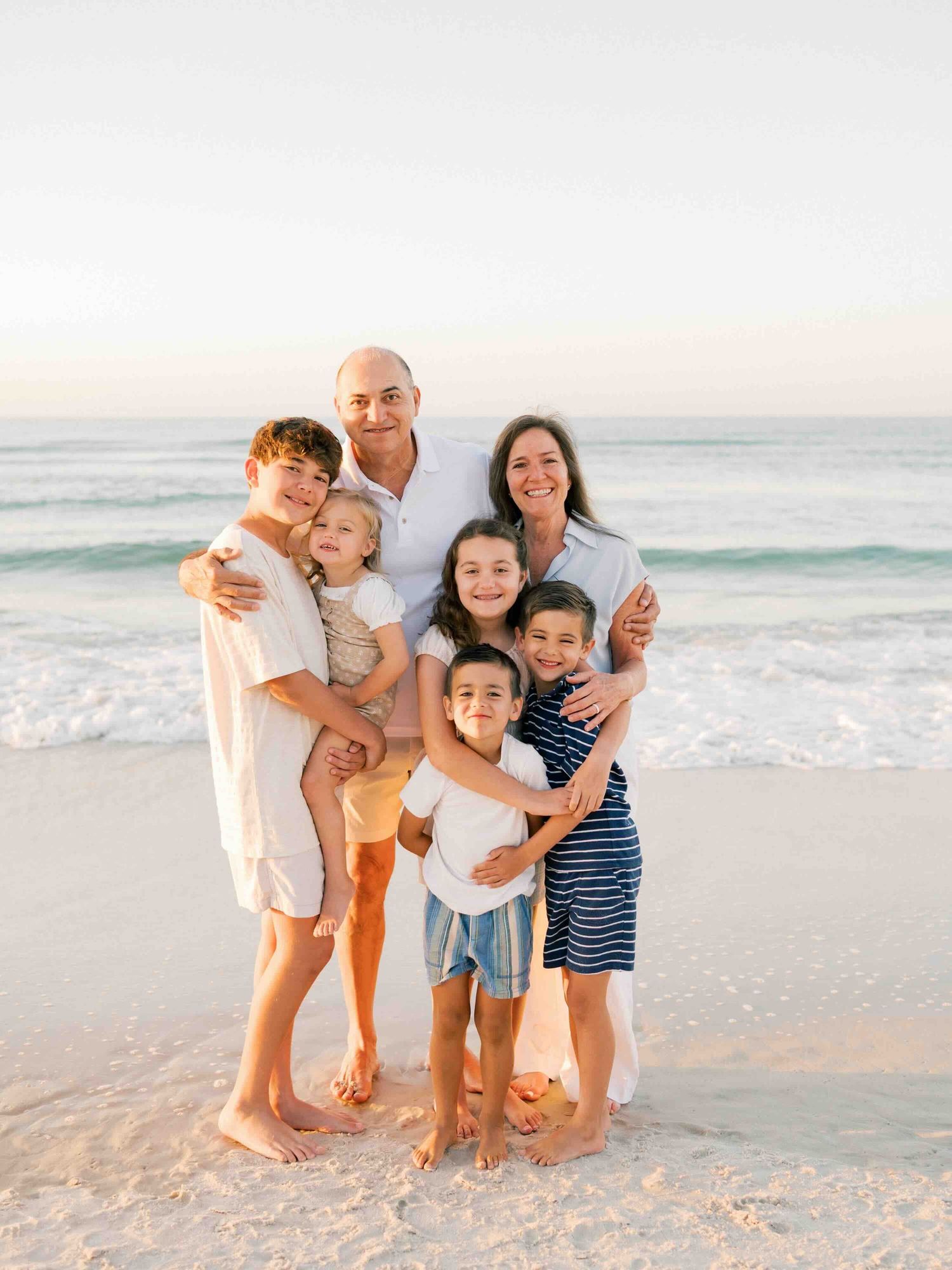 Extended family gathered together on the beach during a sunrise family photography session on Dauphin Island