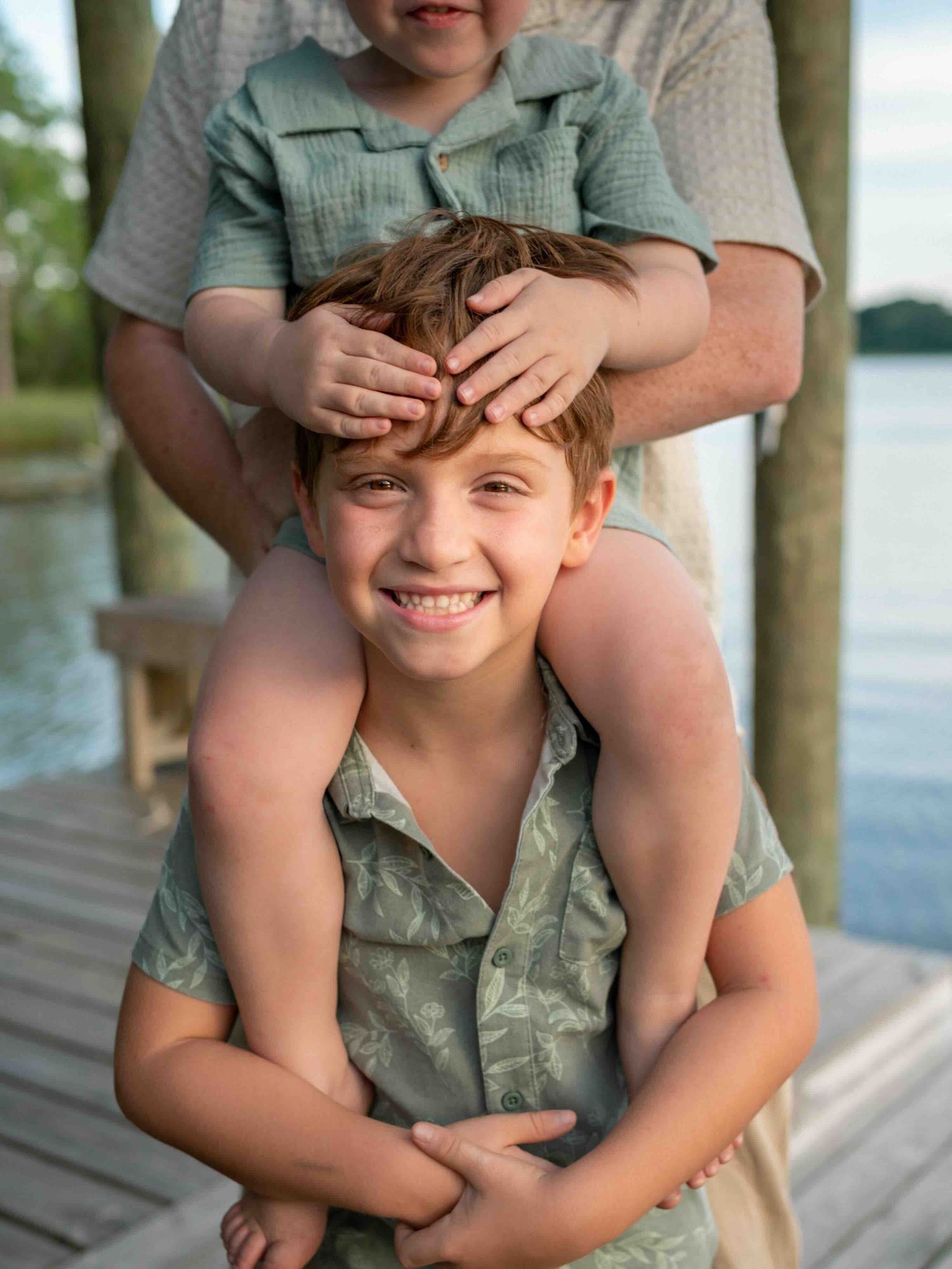 Son smiling while wearing styled beach outfit during a golden hour session in Mobile, Alabama