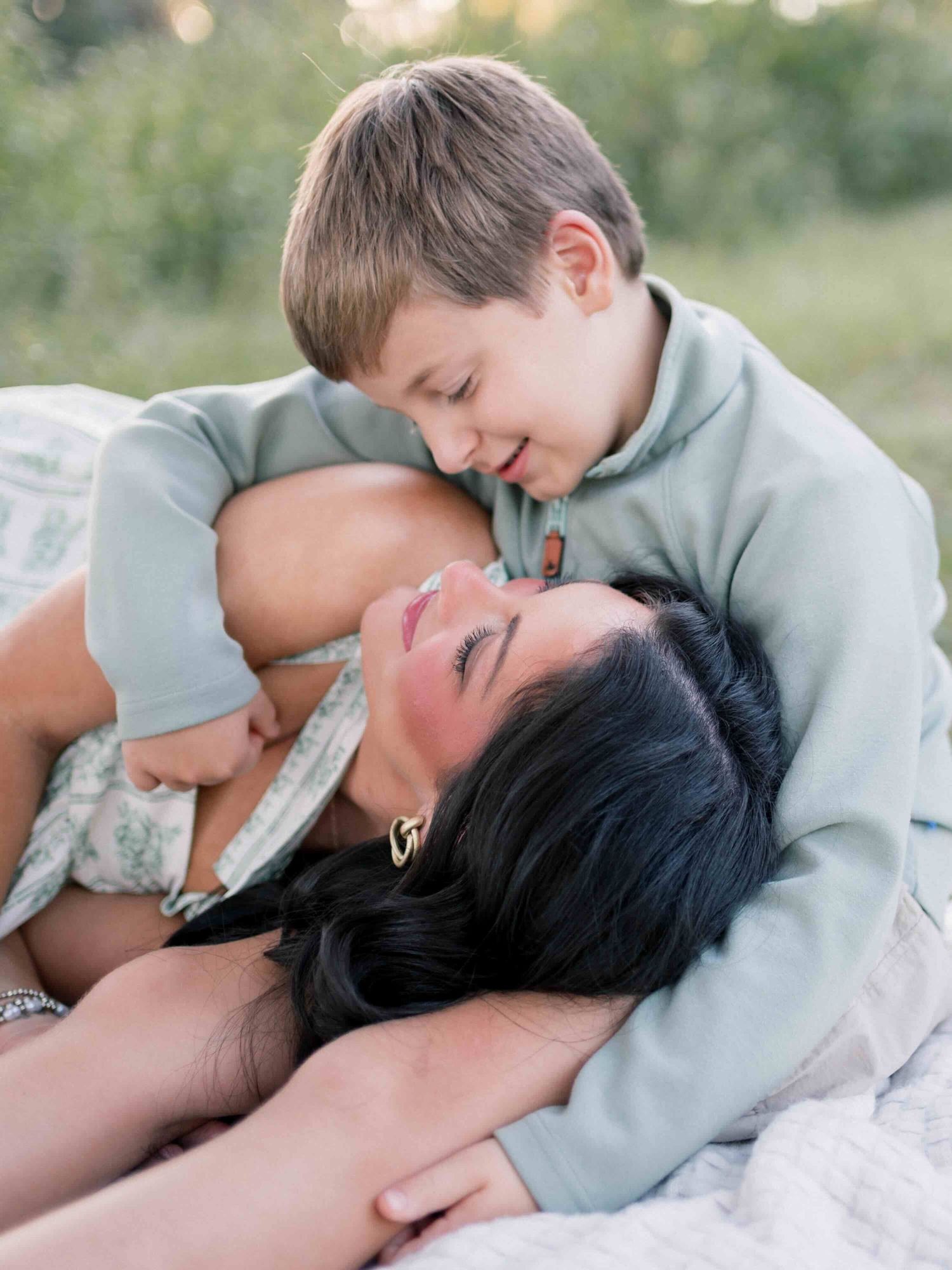Mom and son cuddling during a golden hour family photography session in Mobile Alabama