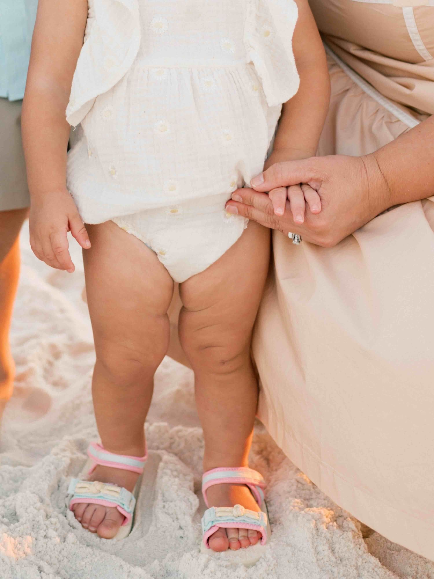 close up of toddlers hand and legs during sunset photography session in orange beach alabama