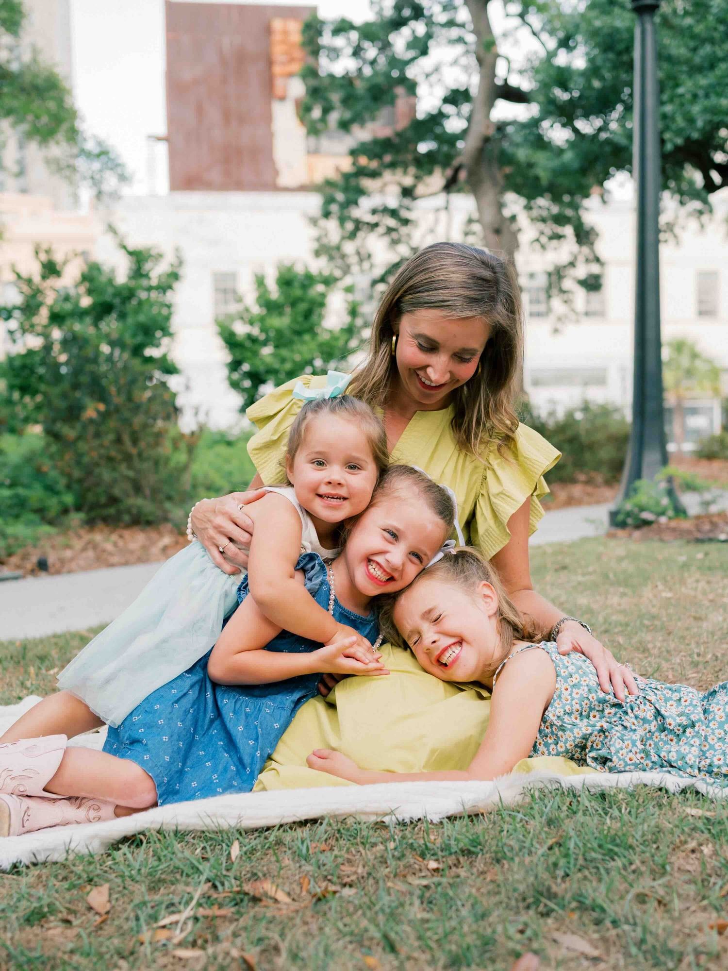 Daughters piled up with mom in Bienville Square during a golden hour photo session
