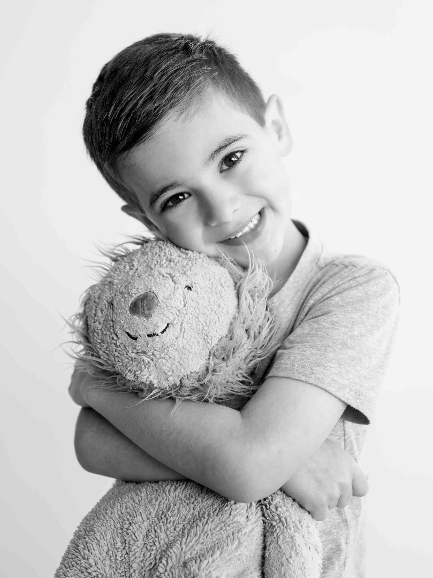 Snuggly child portrait with stuffed animal during kids photography session in Mobile Alabama