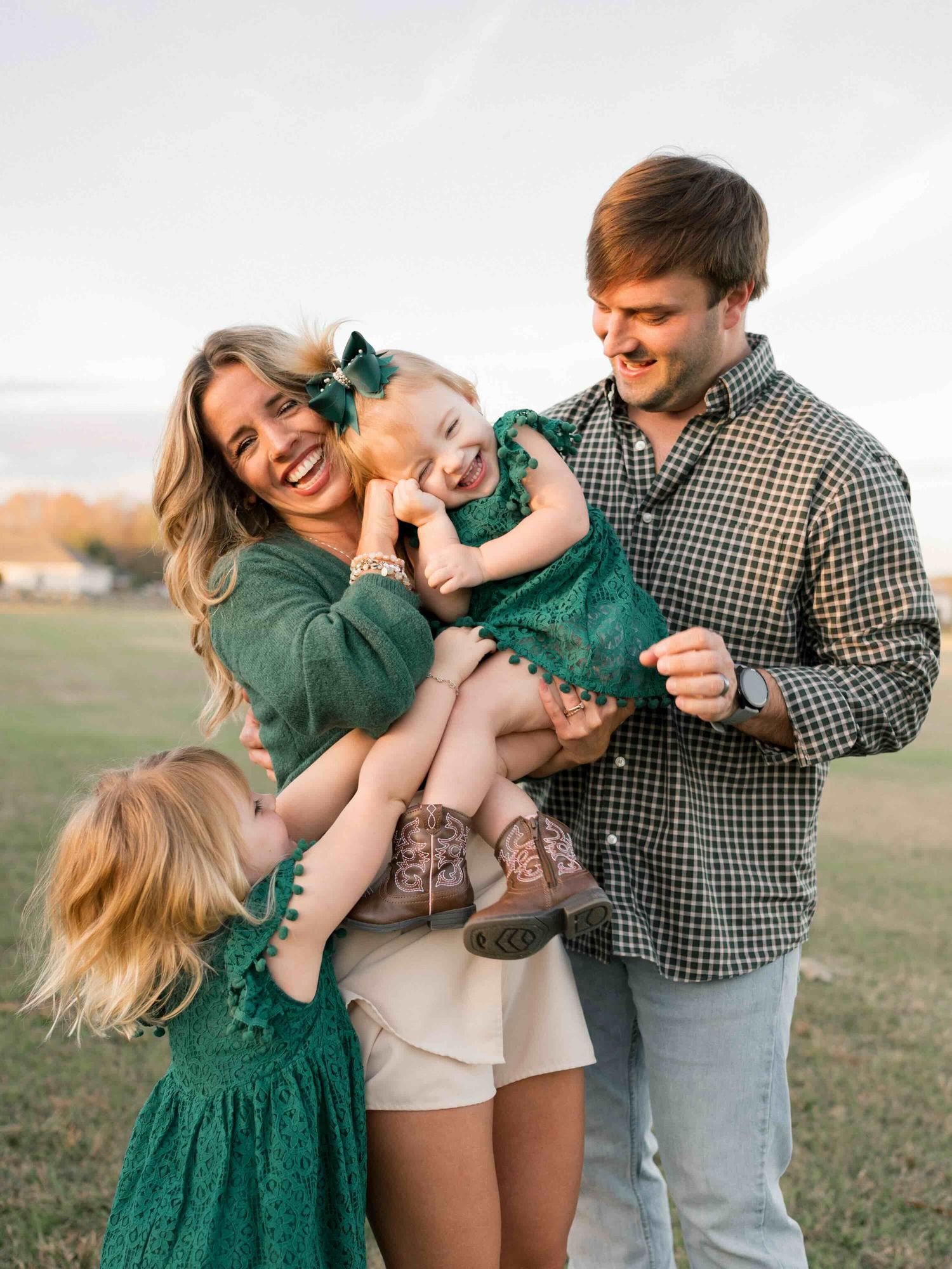 parents and sister tickling daughter, snuggled up laughing during golden hour session in Mobile, alabama