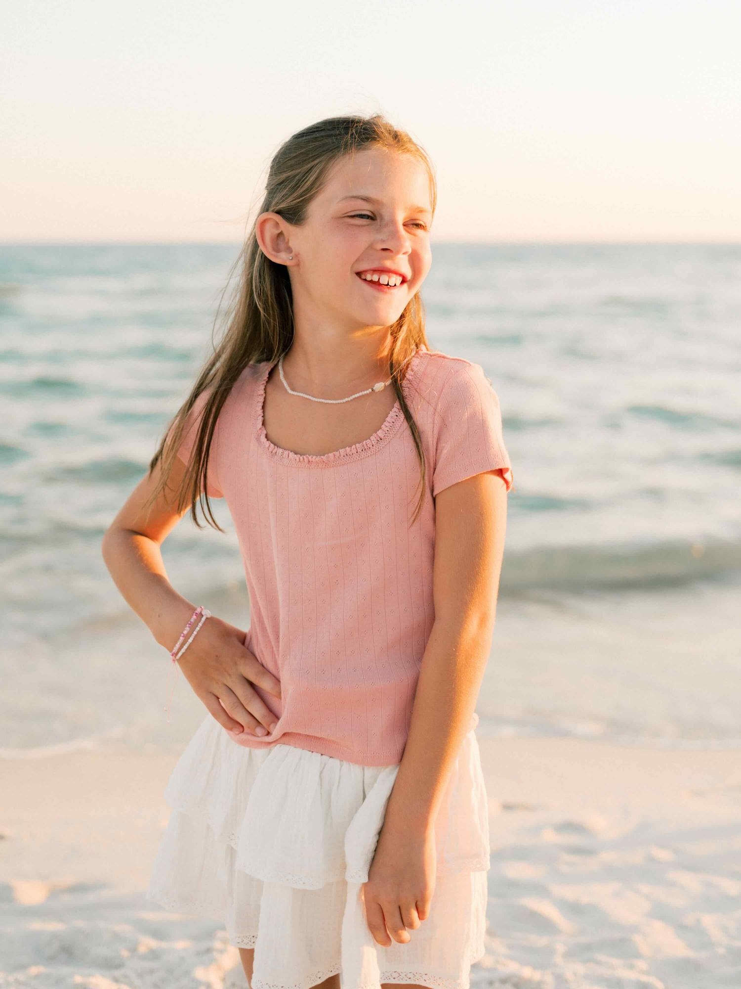 Little girl twirling during sunset beach photography session in Orange Beach Alabama