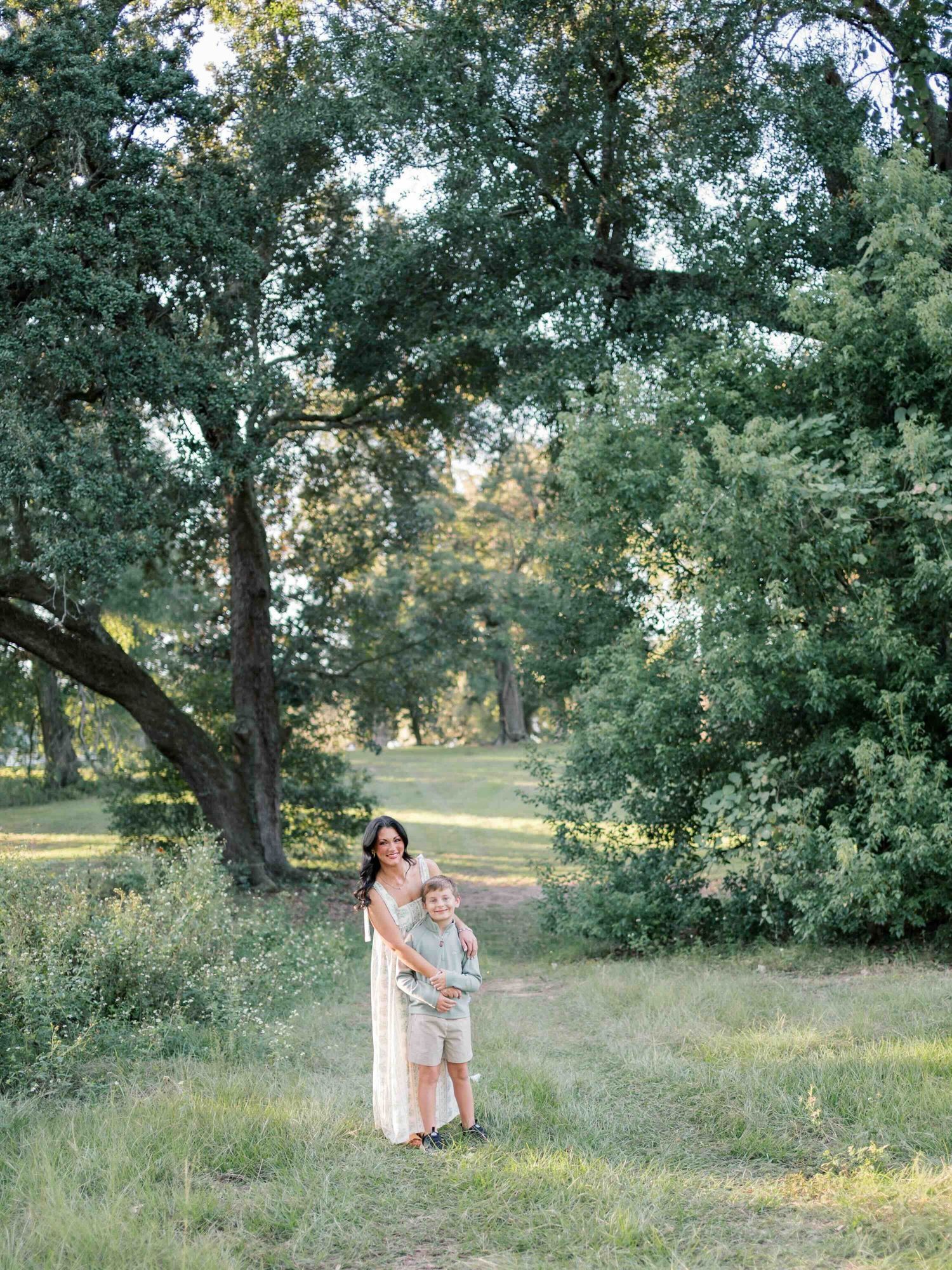 Mom and son laughing beneath live oak trees in Mobile, Alabama family photos