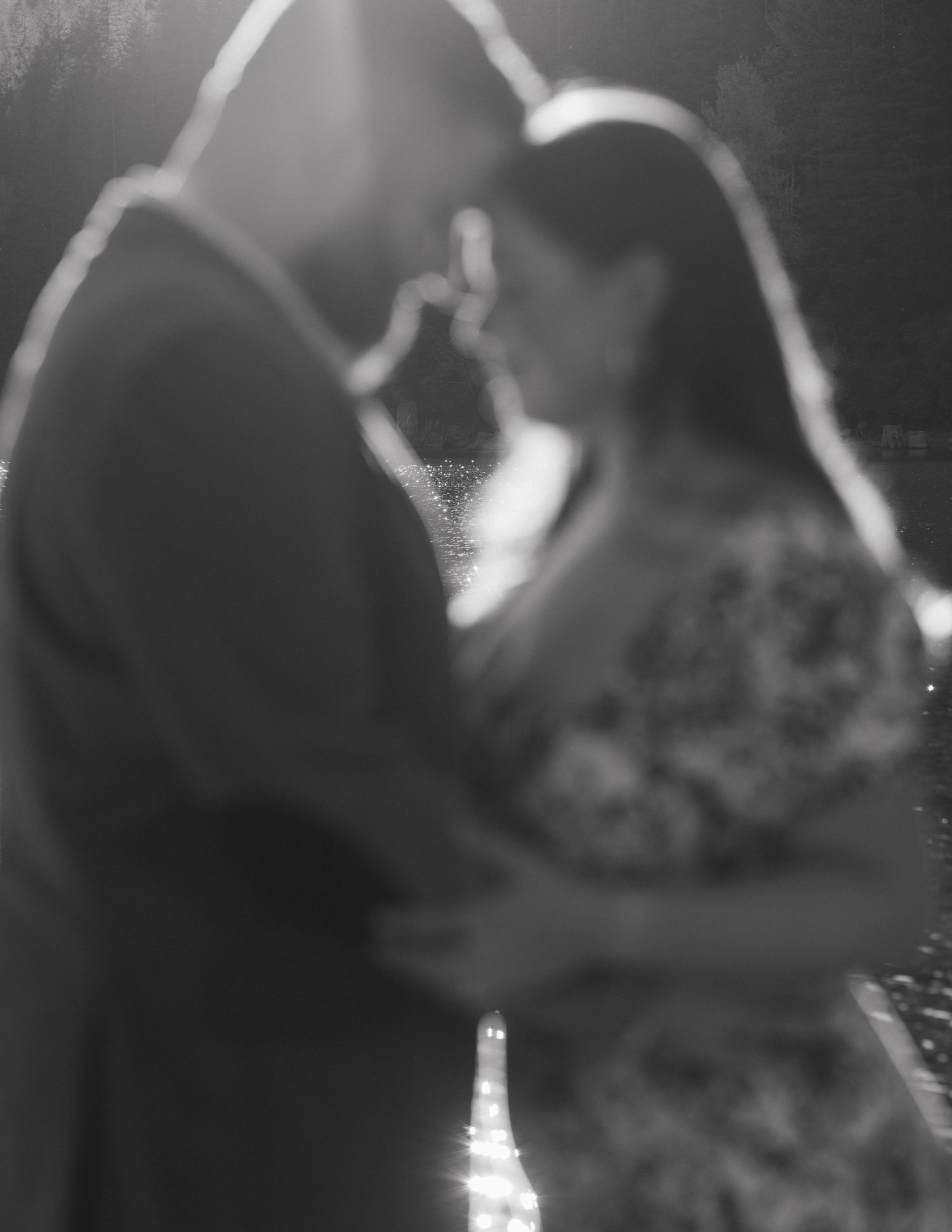 A dreamy black and white portrait of a couple in an intimate moment by the water.