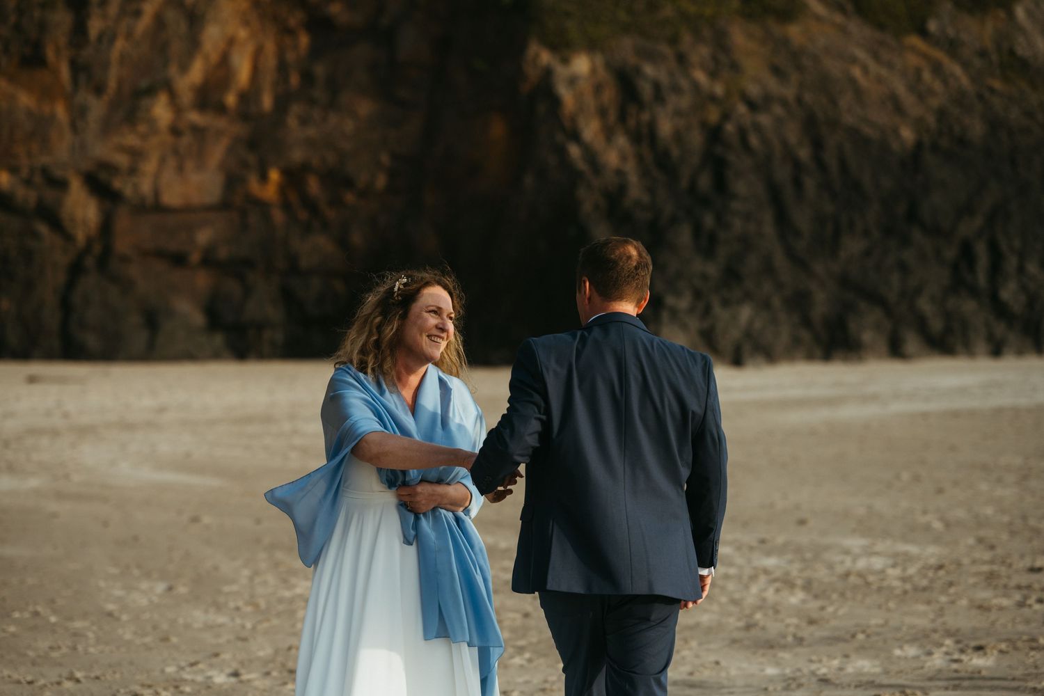 Intimate beach wedding portrait with couple sharing tender moment.