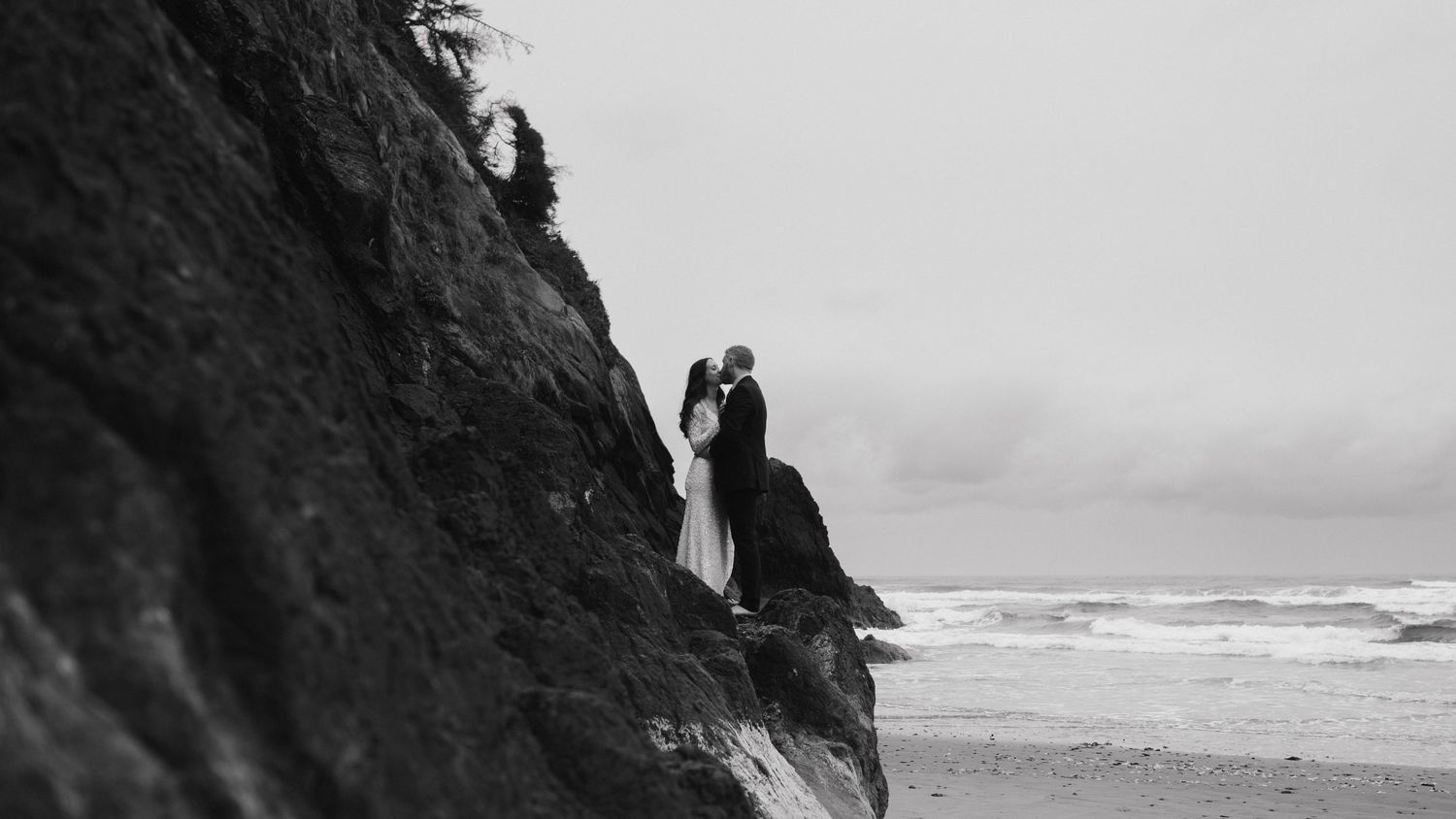 Dramatic black and white coastal landscape with rugged cliffs and ocean waves.