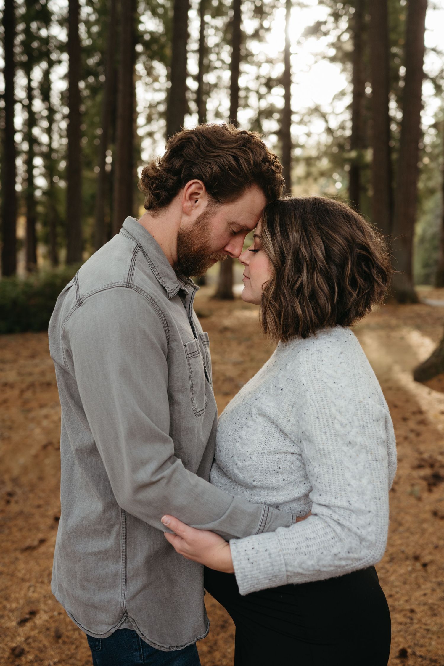 An intimate forest photoshoot sequence showing tender moments among pine trees.