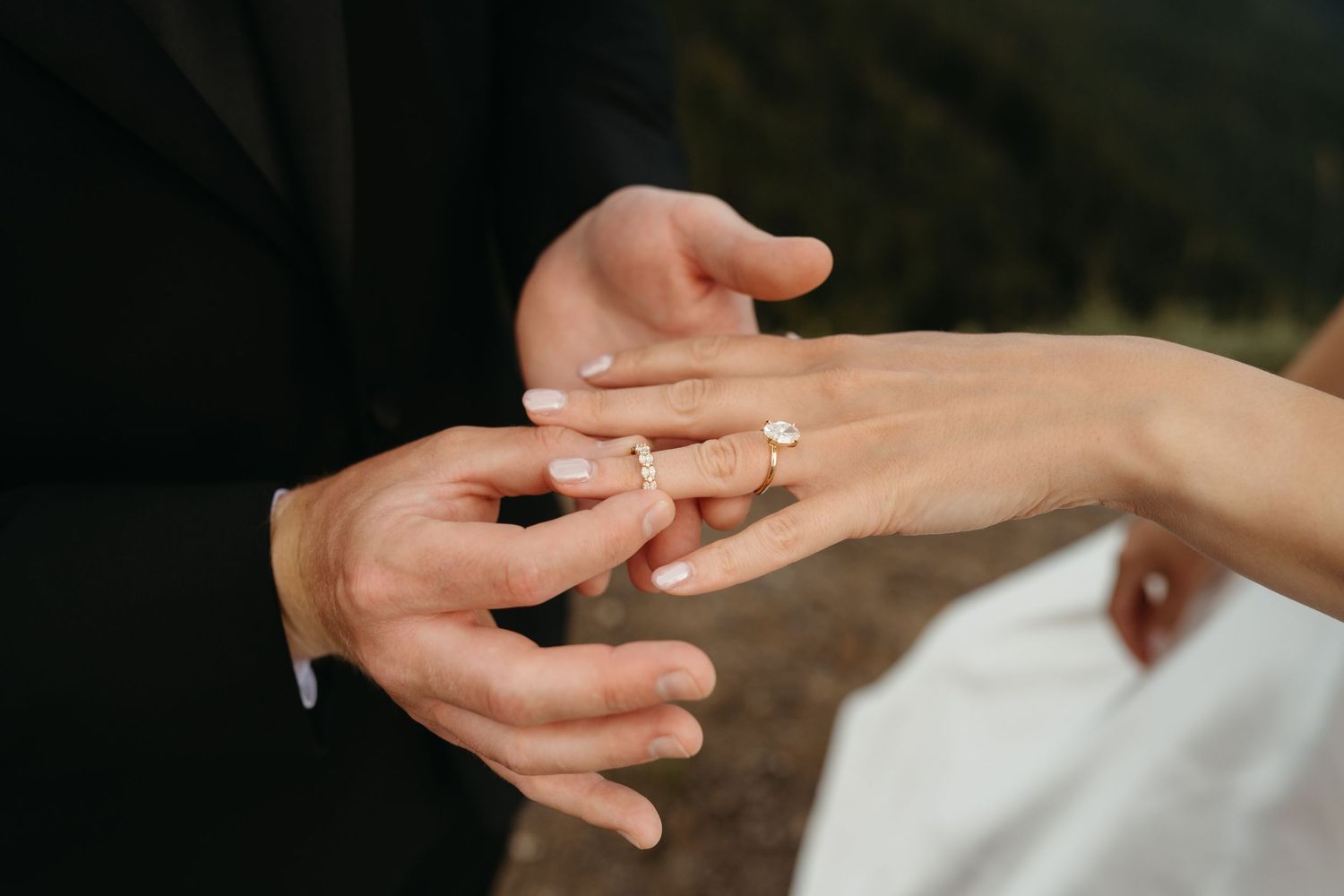Hands tenderly touching during romantic engagement or wedding moment.