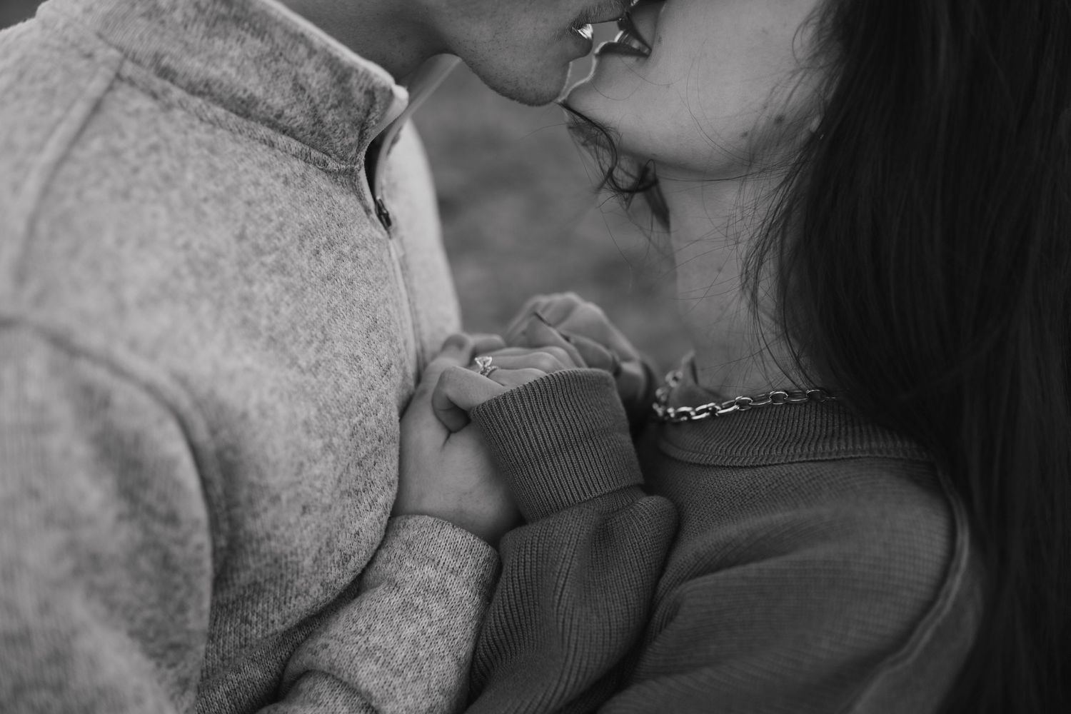 An intimate black and white close-up of a tender embrace between two people.
