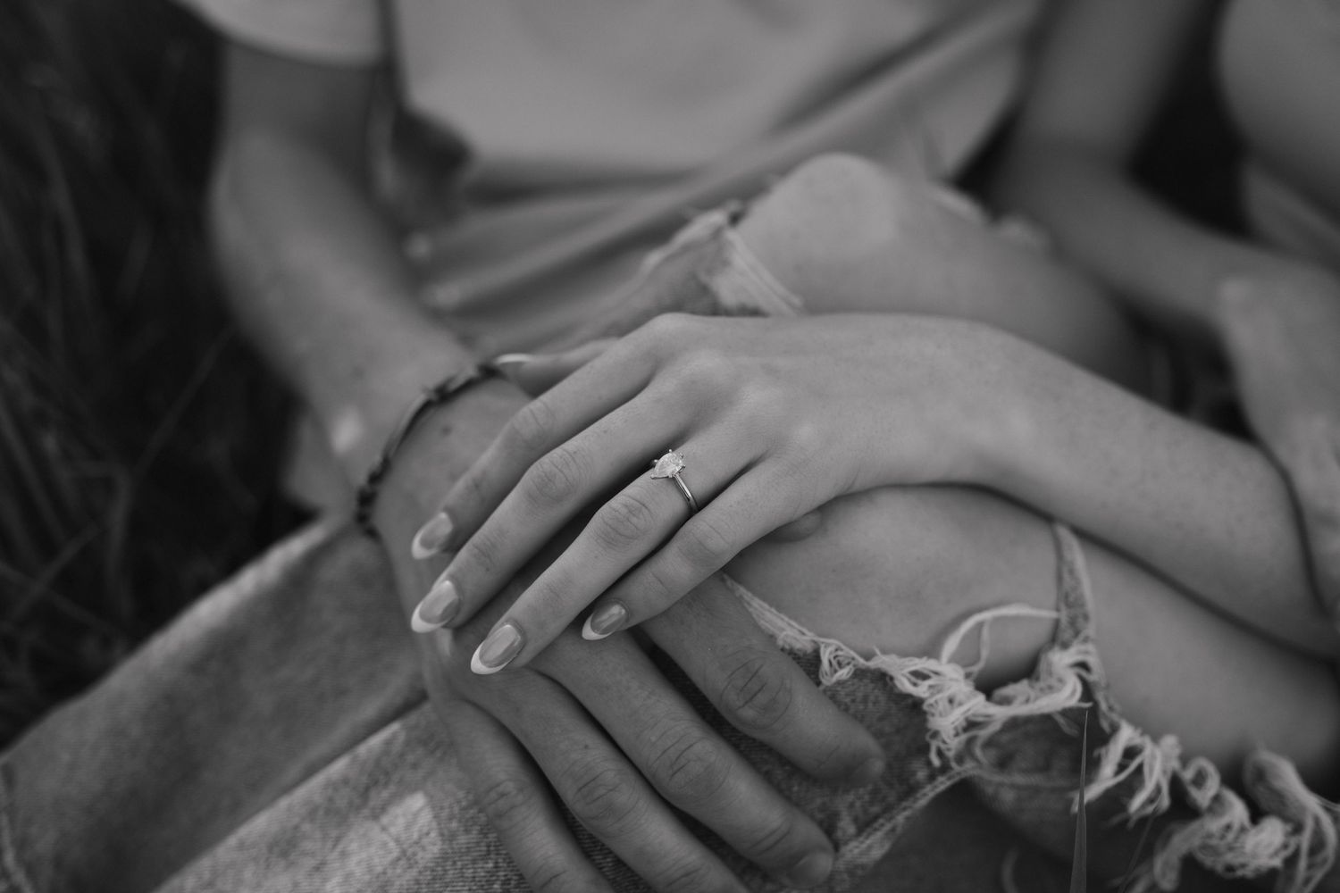 Close-up black and white detail shots of gentle hand touches and embraces.