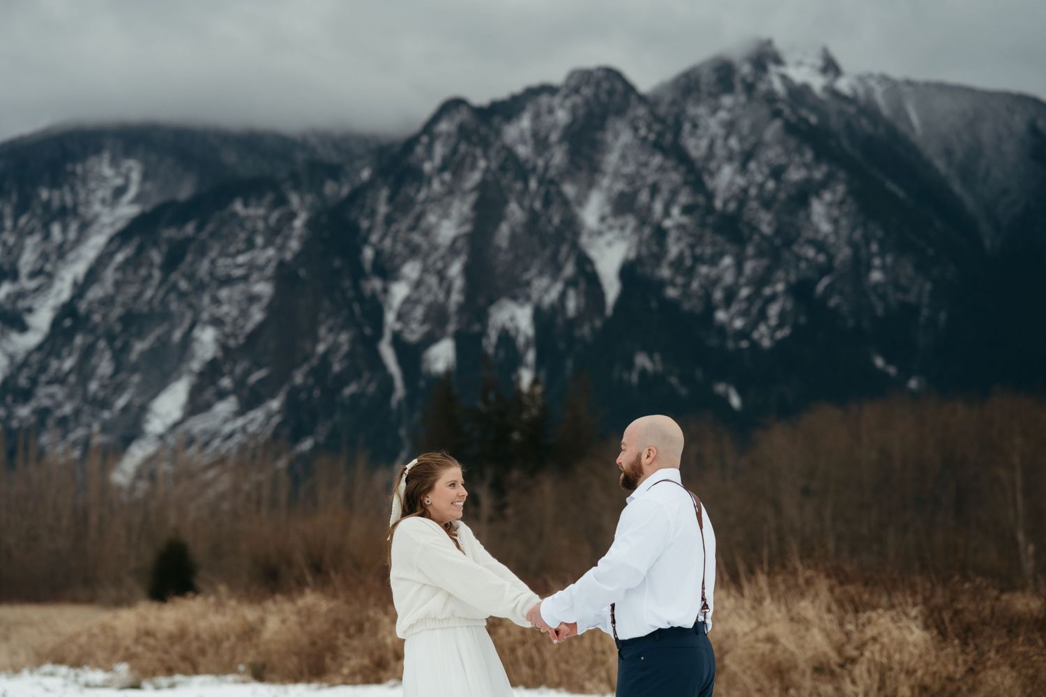 A snowy mountain landscape provides a dramatic backdrop for a winter wedding celebration.