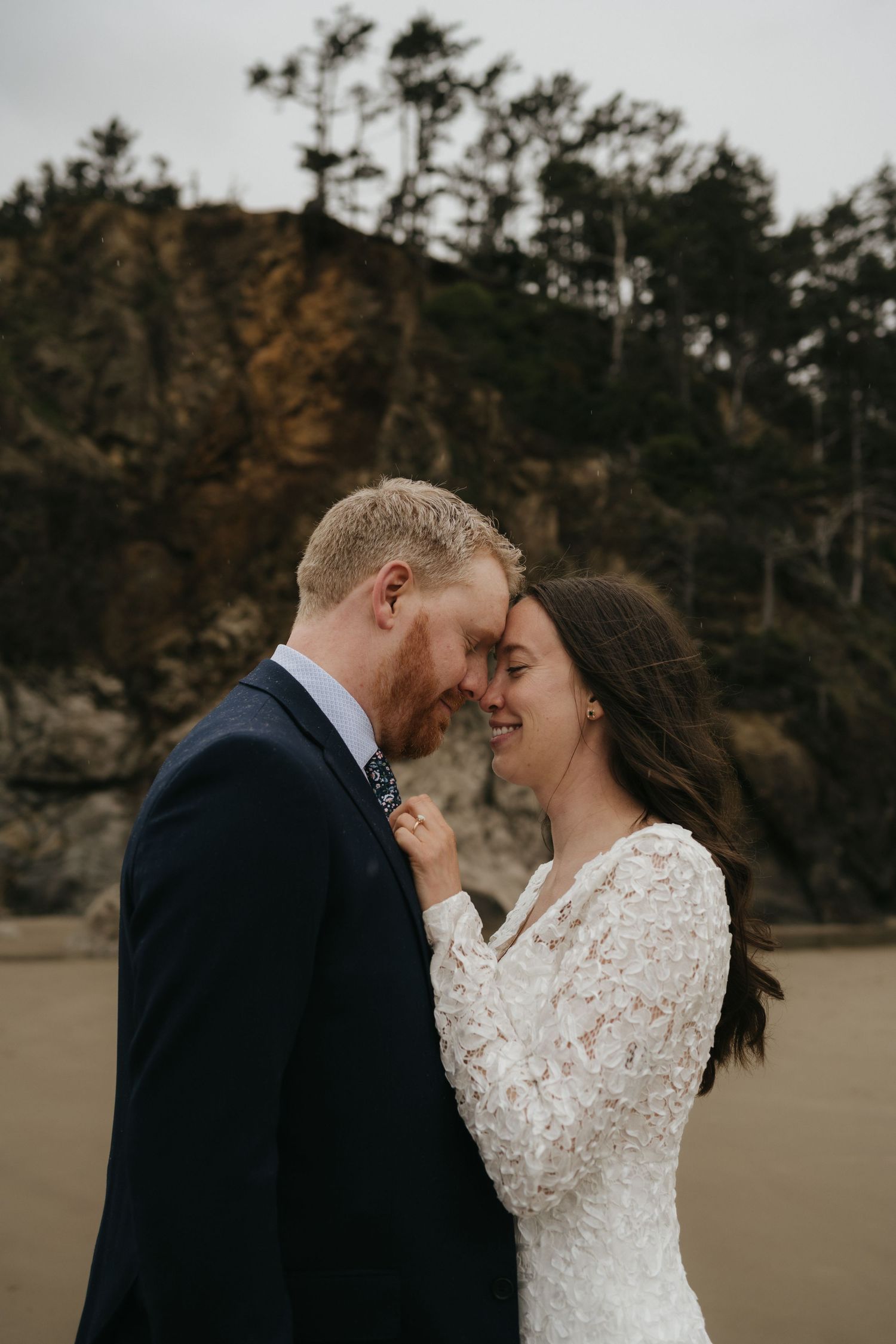 An intimate wedding ceremony moment captured against rugged coastal cliffs at sunset.