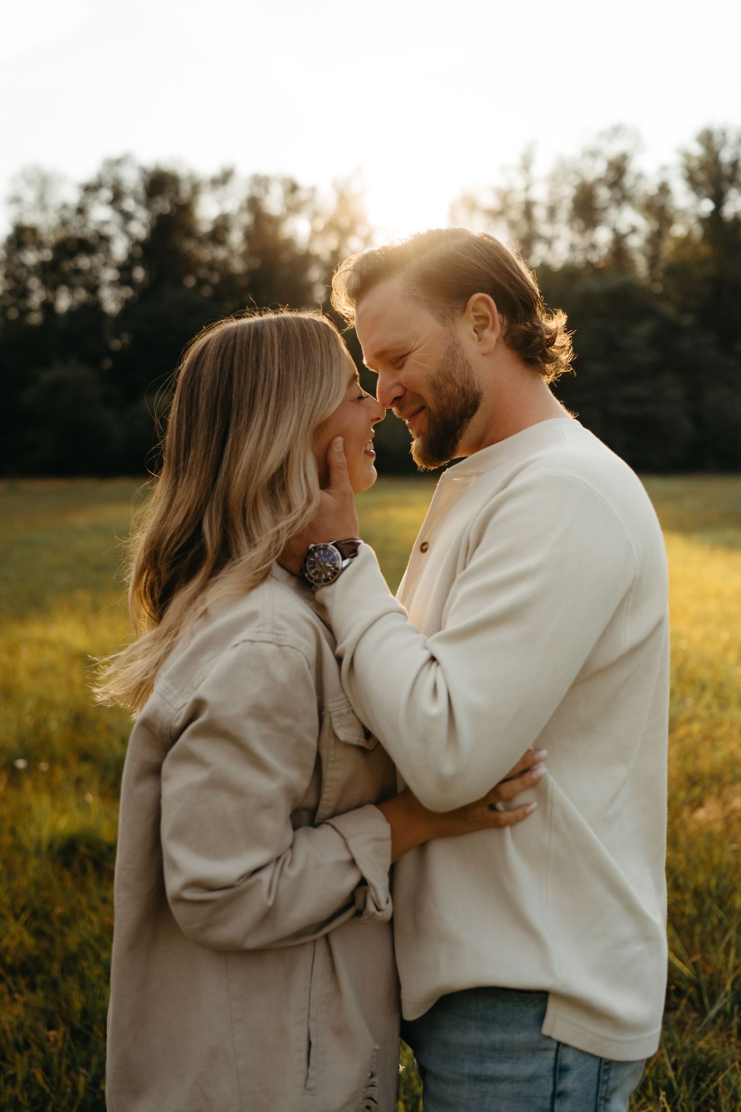 A tender moment between a couple in matching cream sweaters during golden hour.