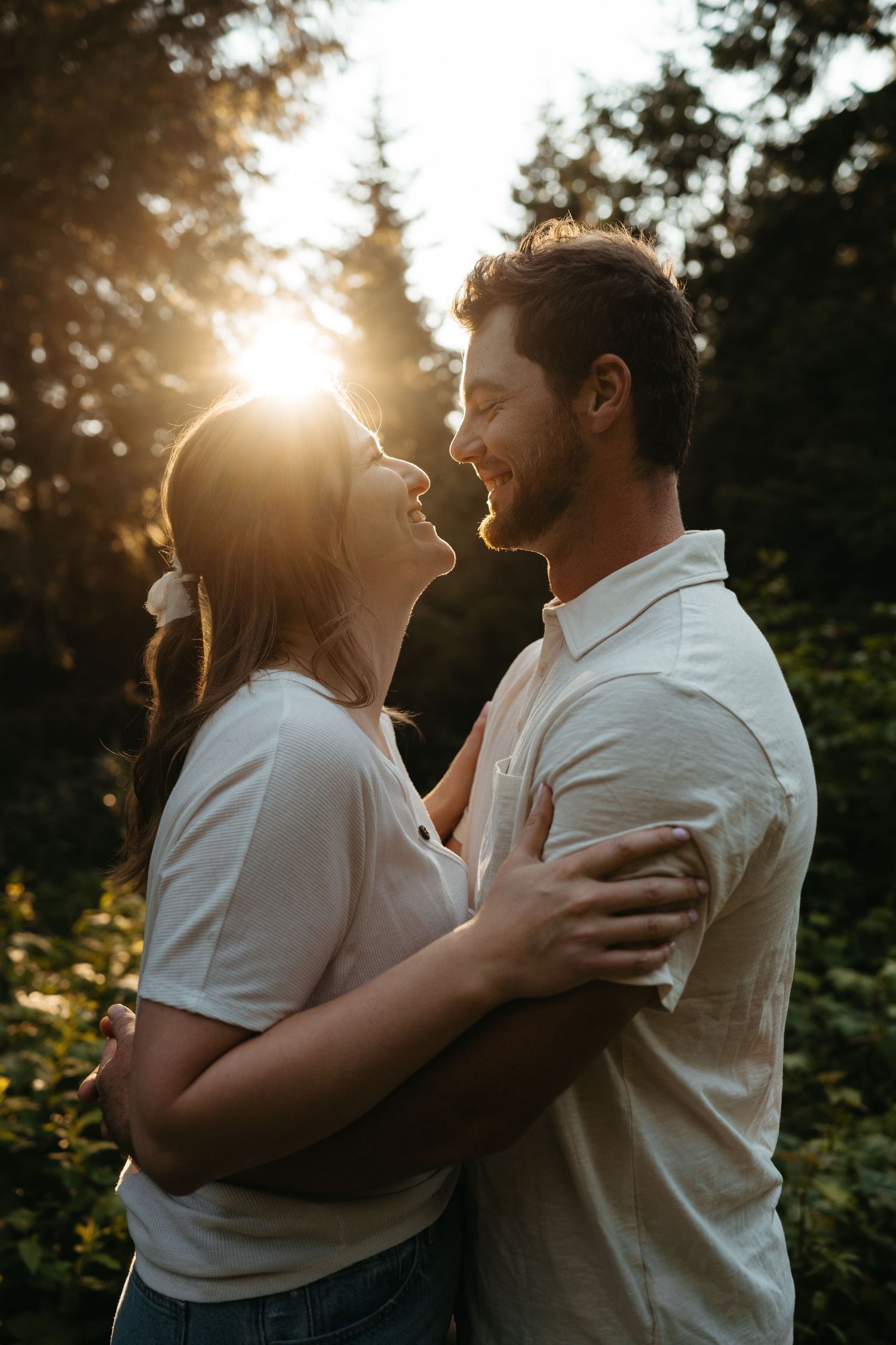 Romantic sunset portrait in forest with light streaming through trees.