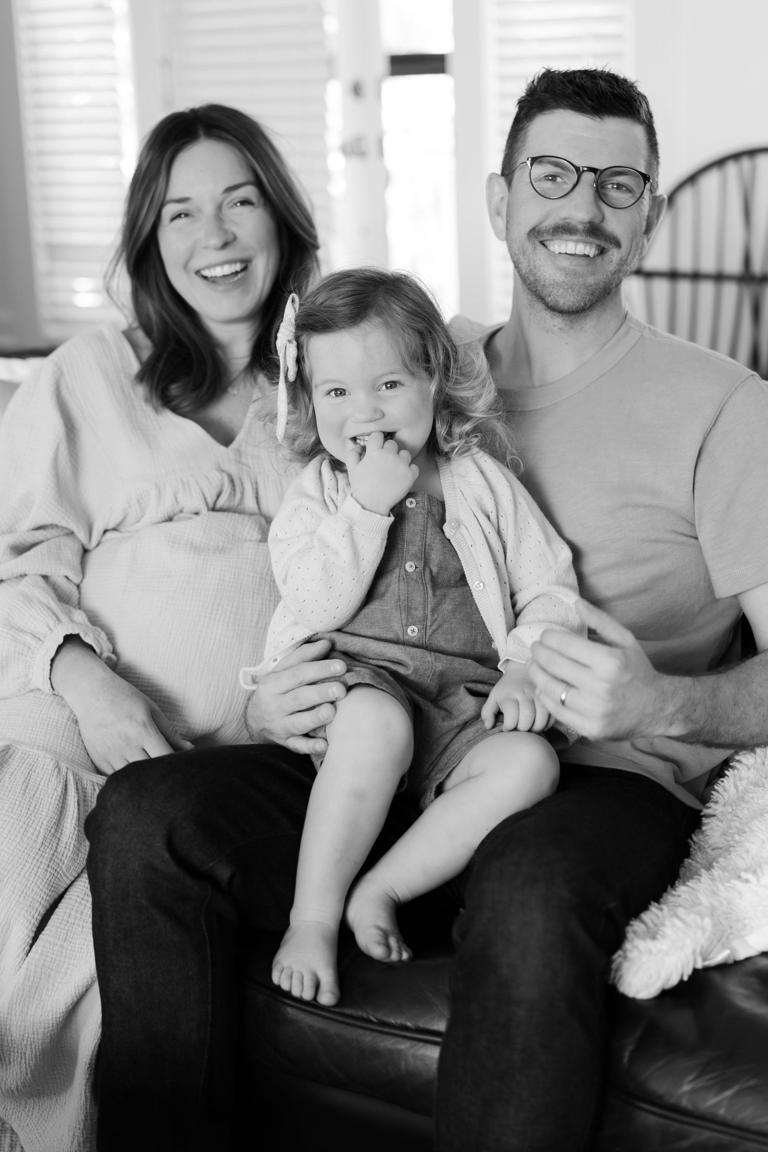 Black and white photo of a family lounging together on their couch.
