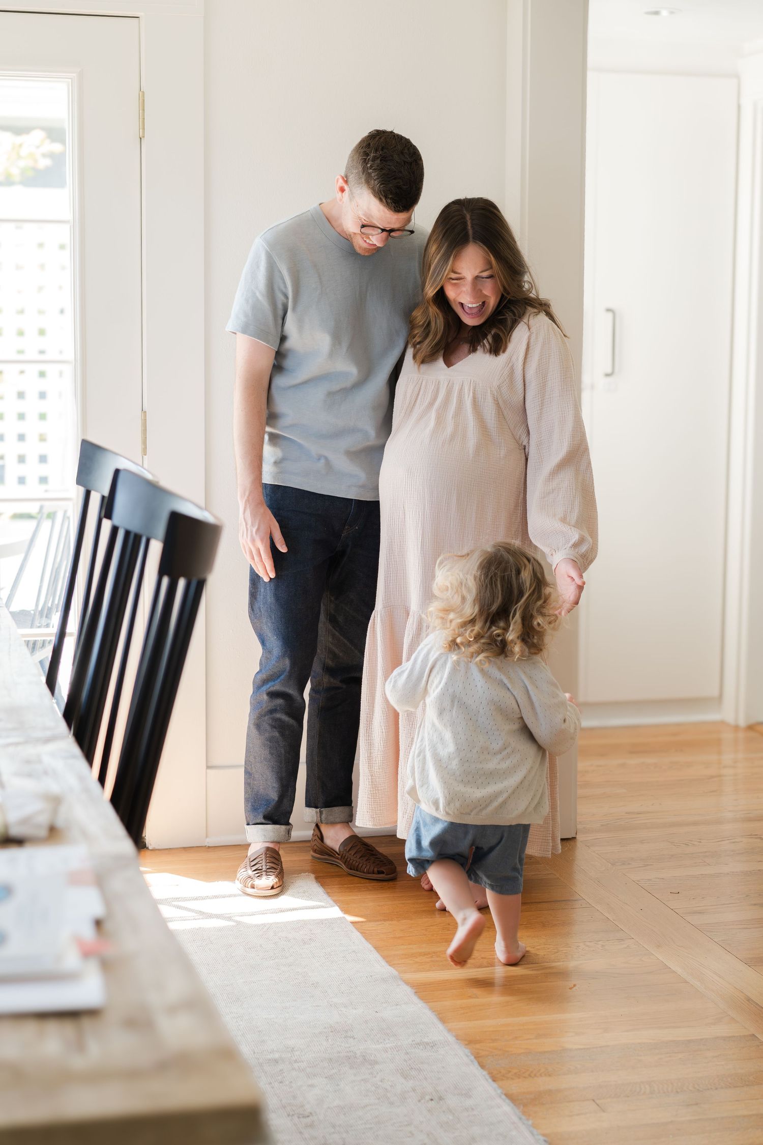A candid family scene with natural lighting showing three people sharing a moment together.