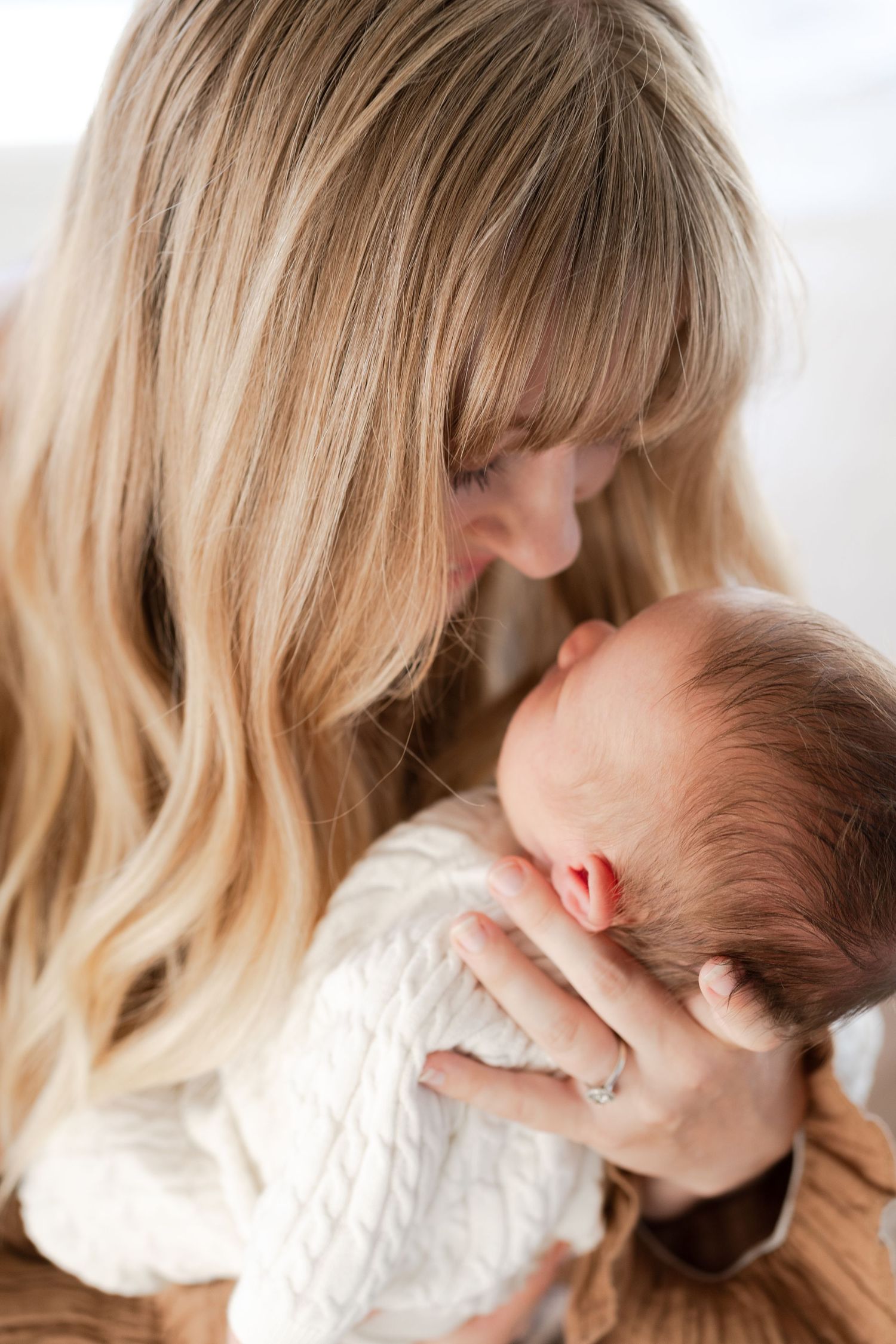 Close-up portraits showing tender moments between parent and newborn baby.