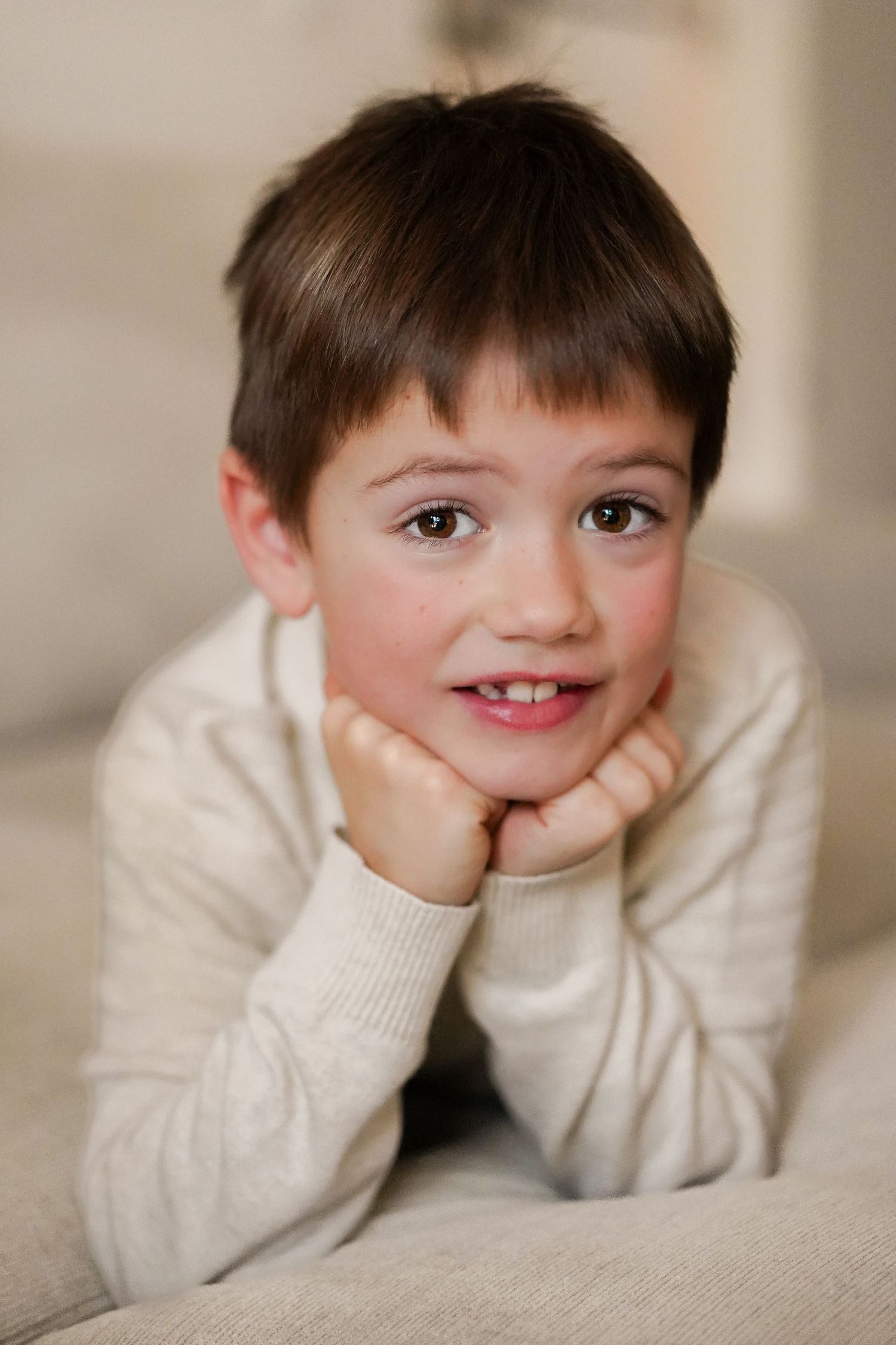 Close-up portrait series showing cheerful expressions in cream sweater.