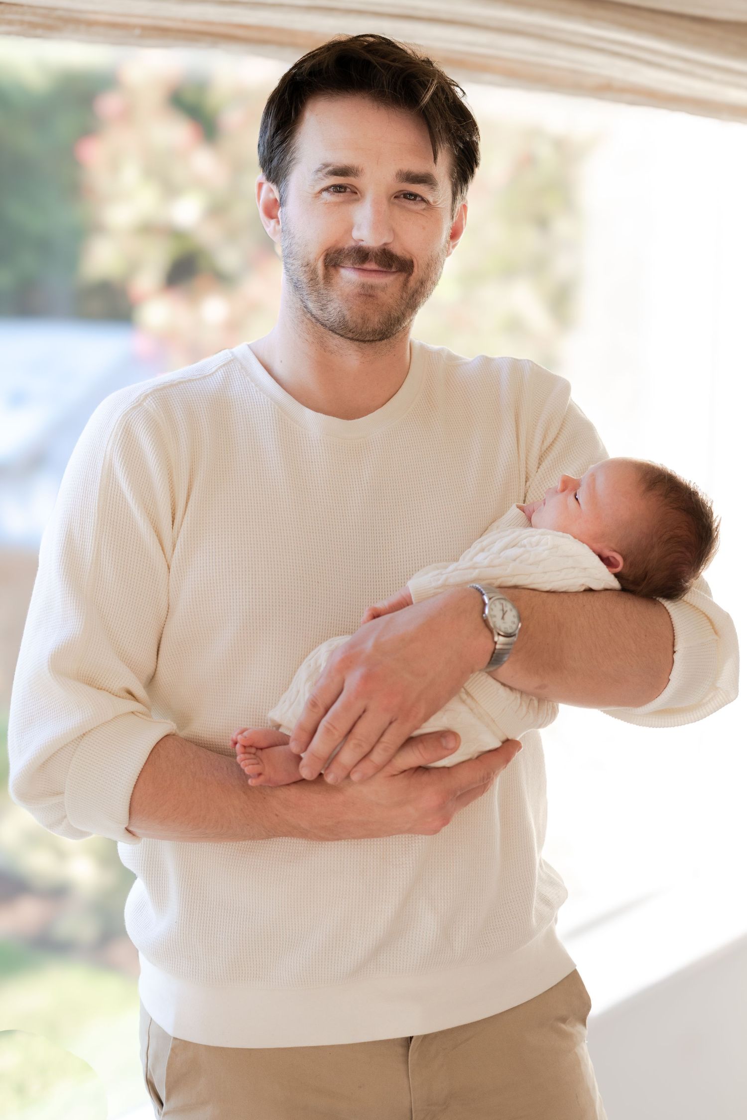 A series of tender moments showing a parent cradling and bonding with a newborn baby in a bright indoor setting.