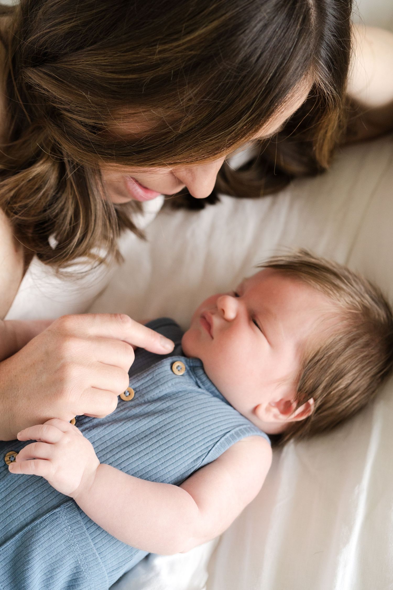 Intimate bonding moment between parent and baby in blue clothing.