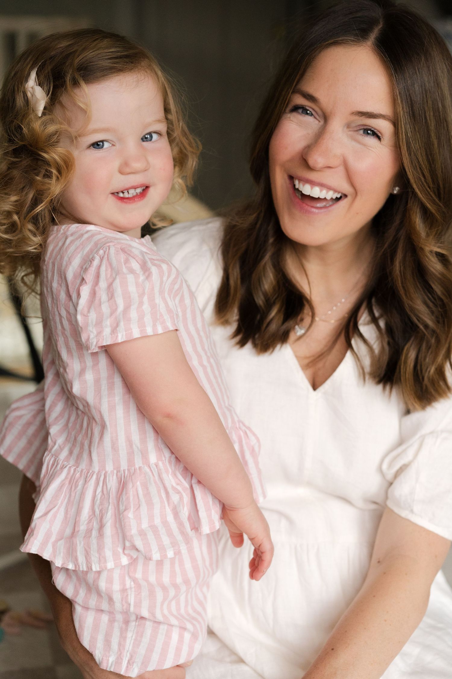 Candid color photos capturing loving interaction between parent and child wearing coordinated white and pink.