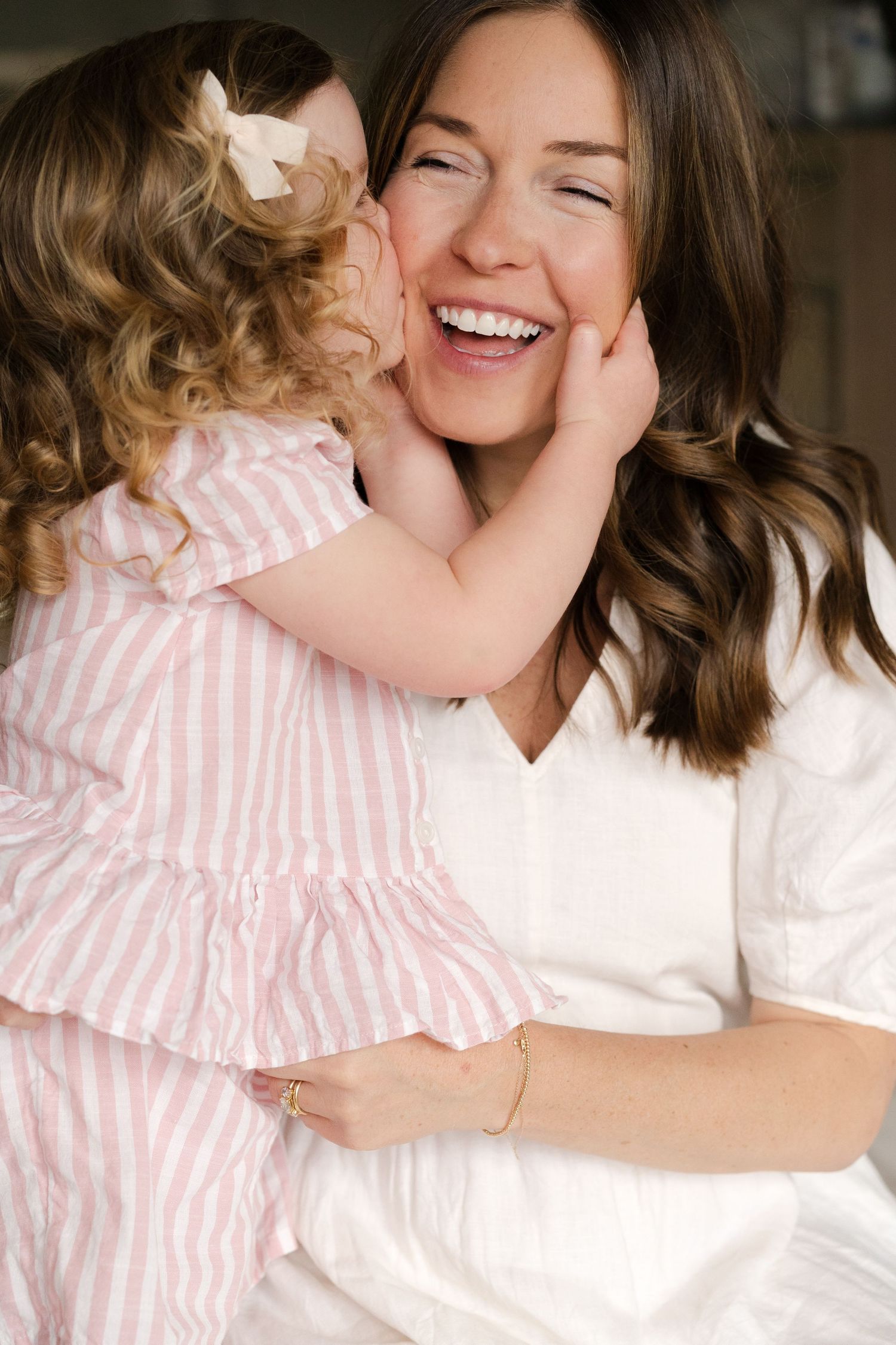 Heartwarming series of embraces between parent and child wearing white and pink striped outfits.