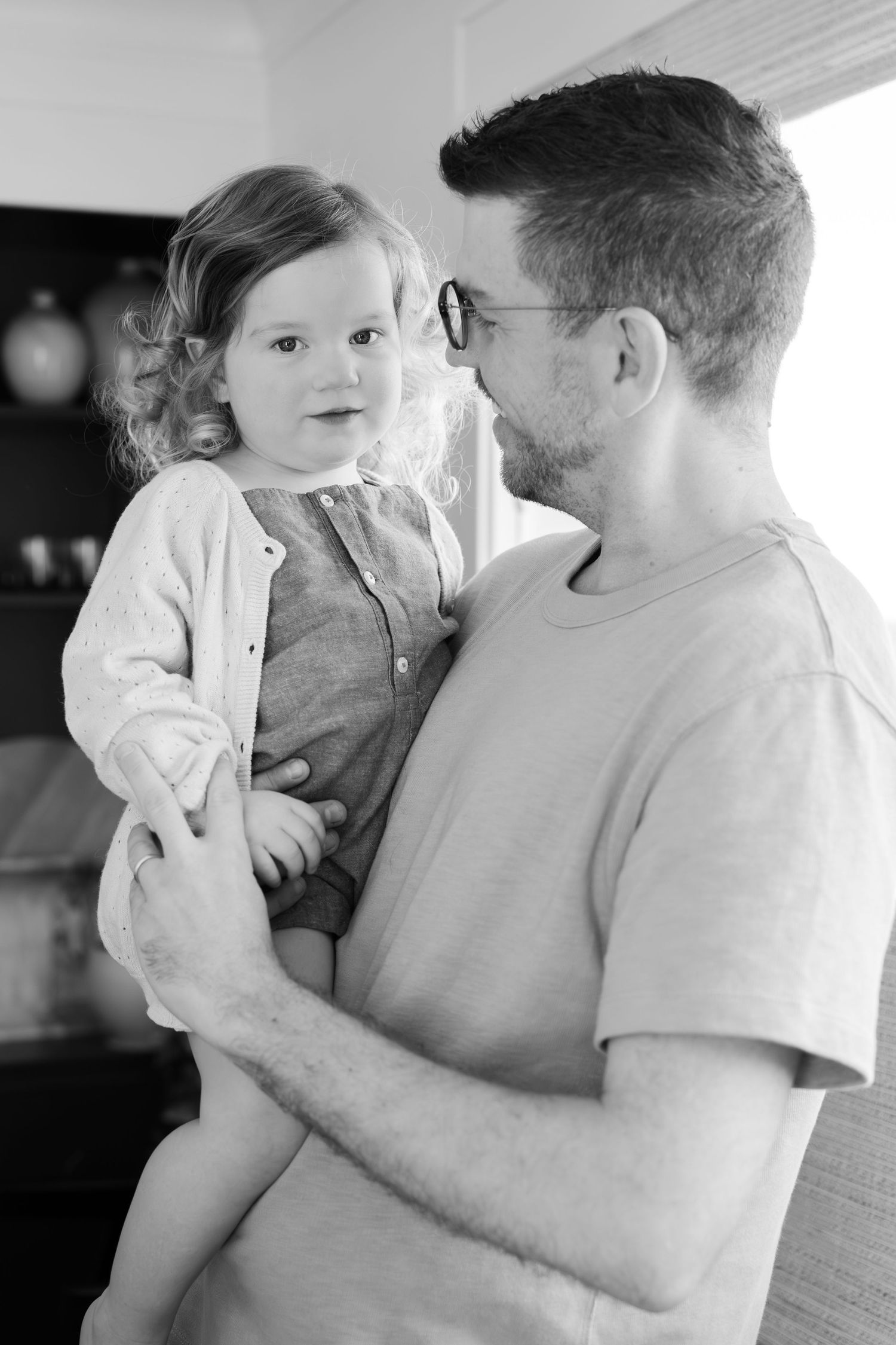 A black and white portrait capturing a tender moment between parent and child.