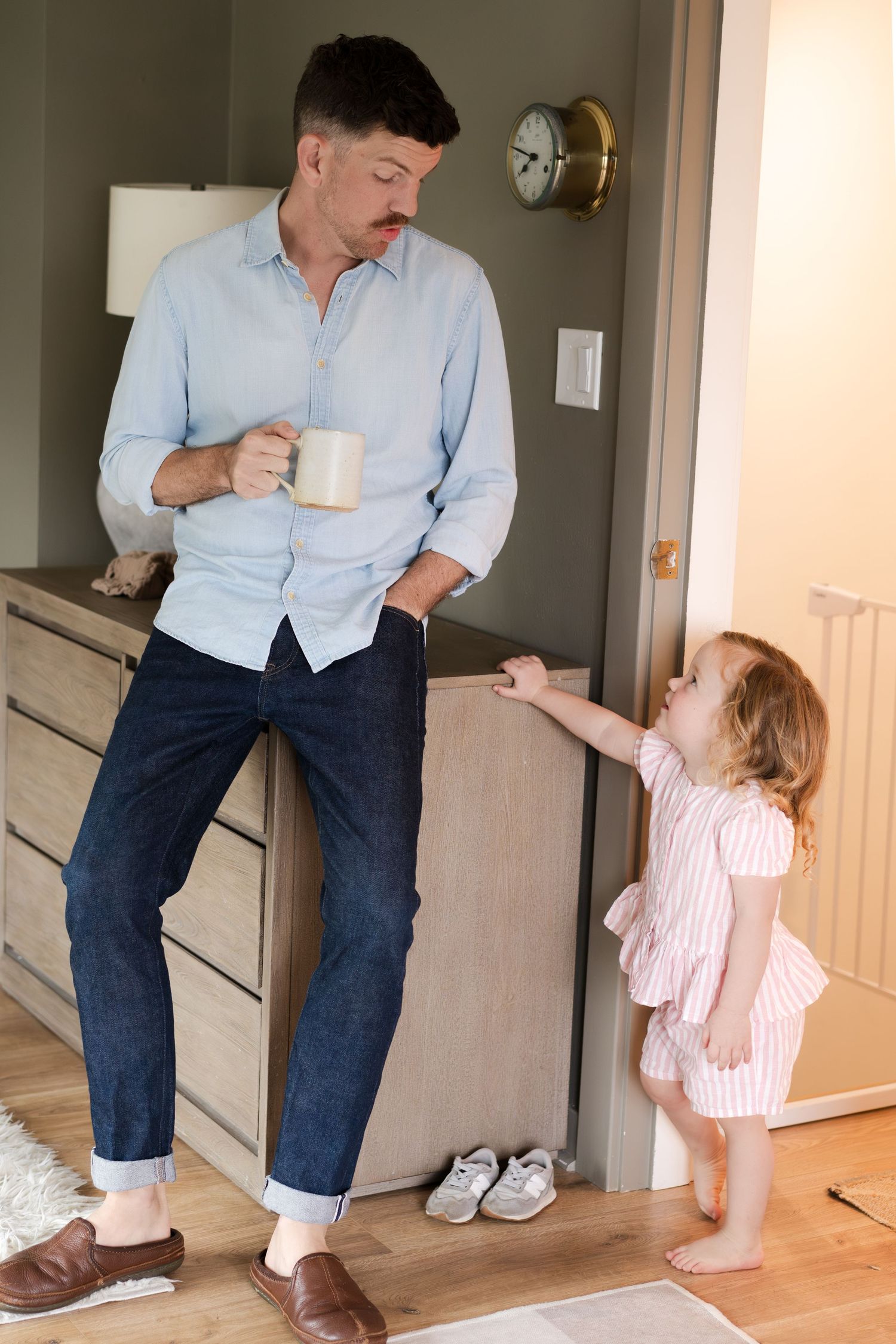 A joyful chase sequence down a hallway with hardwood floors and white walls.