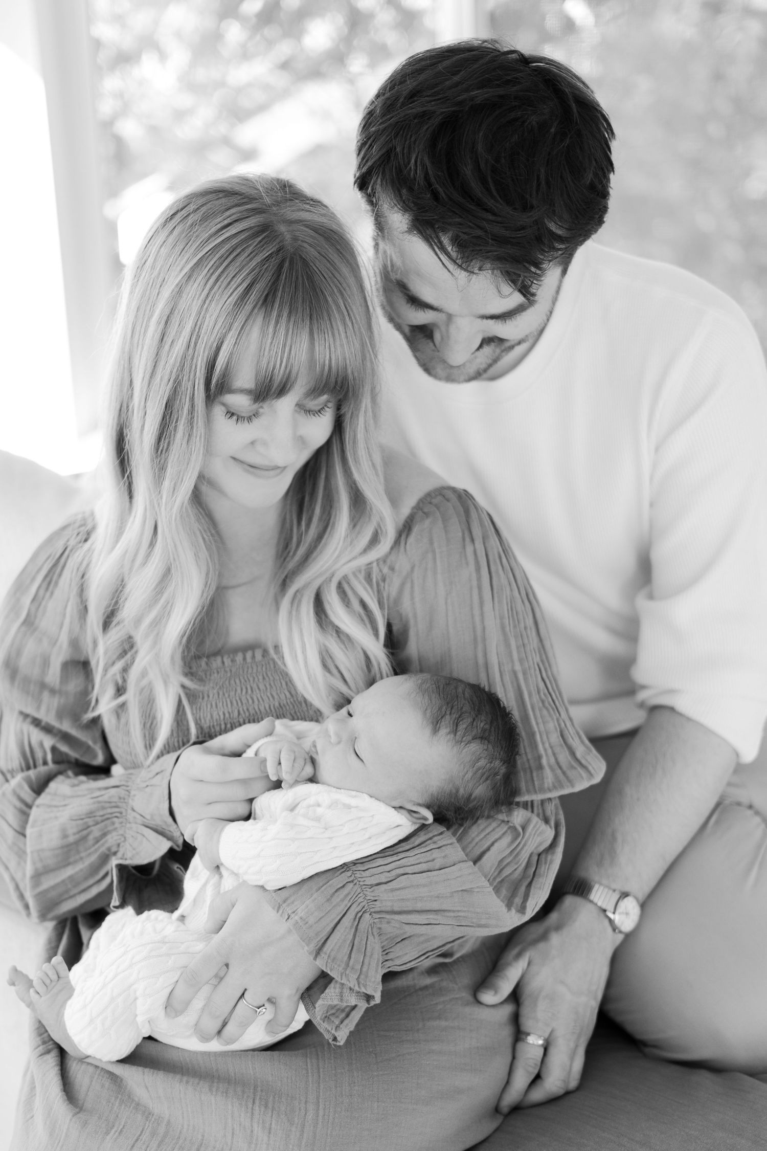 Intimate family moment as parents gaze lovingly at their newborn baby.