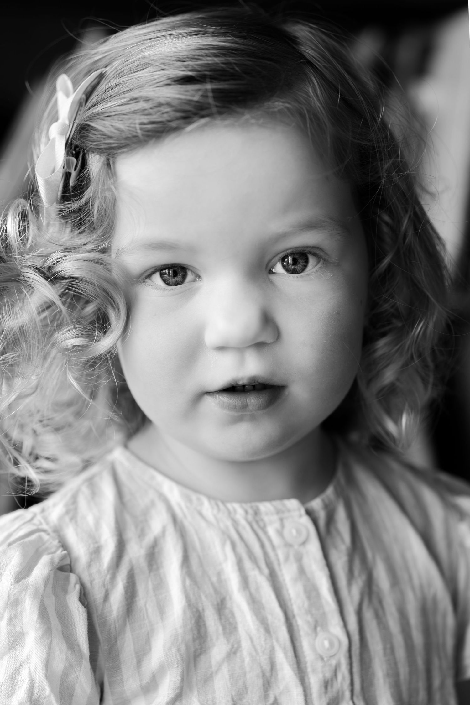 Black and white portrait series showing sweet expressions and curly hair.