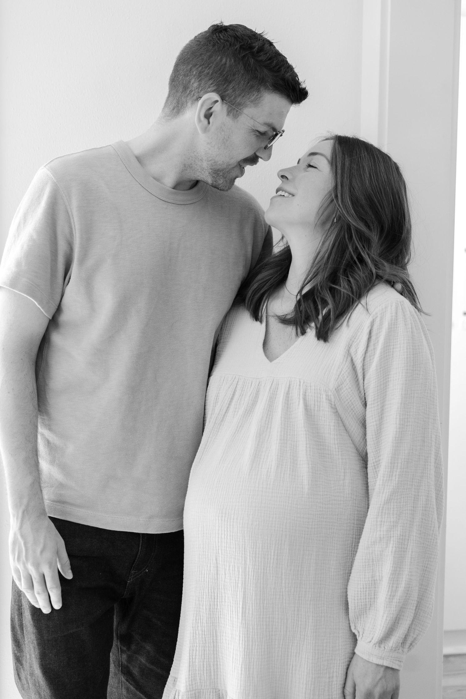 An intimate black and white portrait of a couple sharing a tender moment.