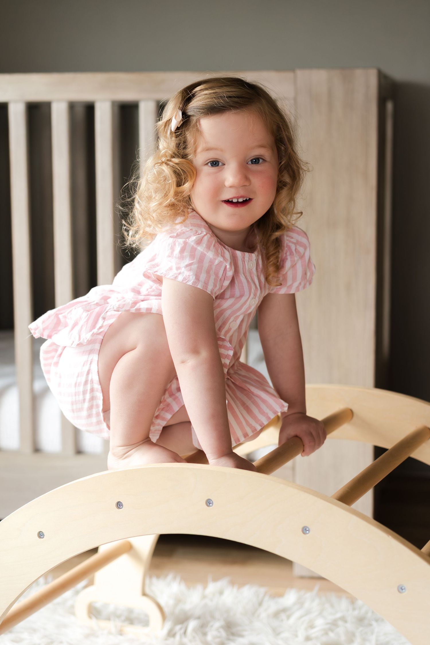 A sweet moment captured while playing on a wooden rocking toy.