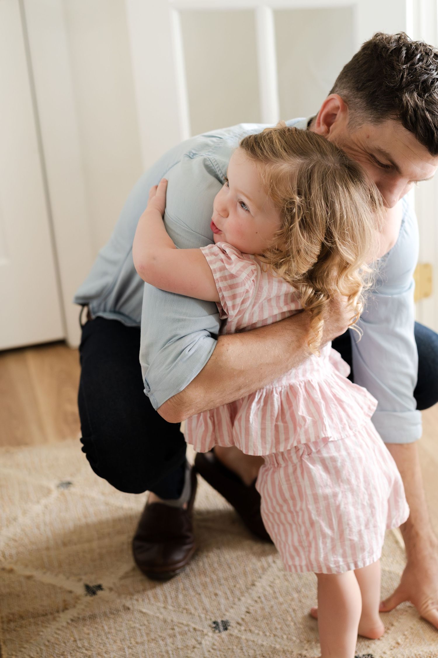 Sweet playtime moments captured between a child and adult on a carpeted floor.