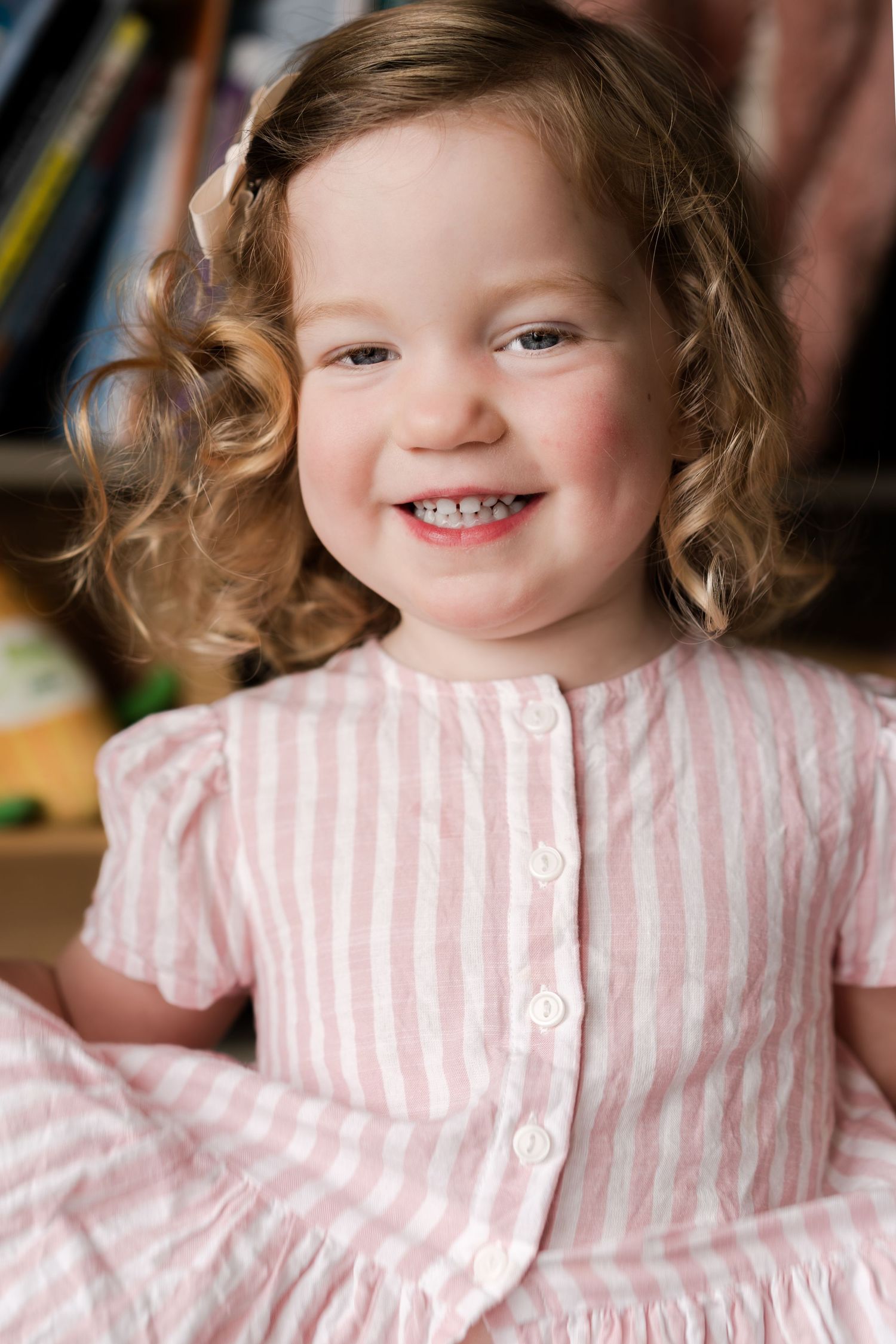 Close-up shots showing happy expressions in a pink striped outfit.