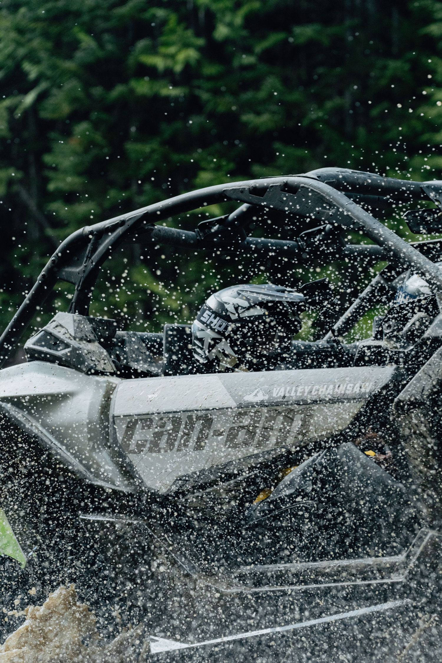 Can-Am side-by-side UTV covered in water droplets during an off-road adventure.
