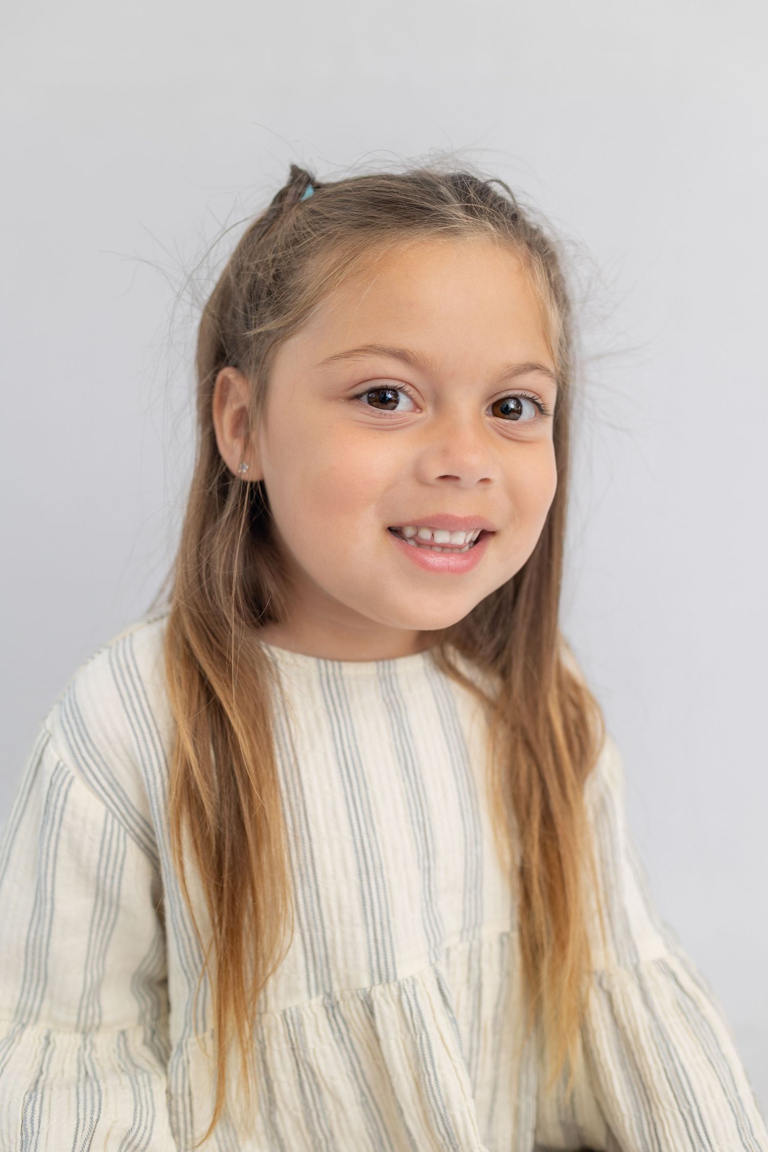 Young girl smiling naturally during candid school photo day, Elaine Woo Photography